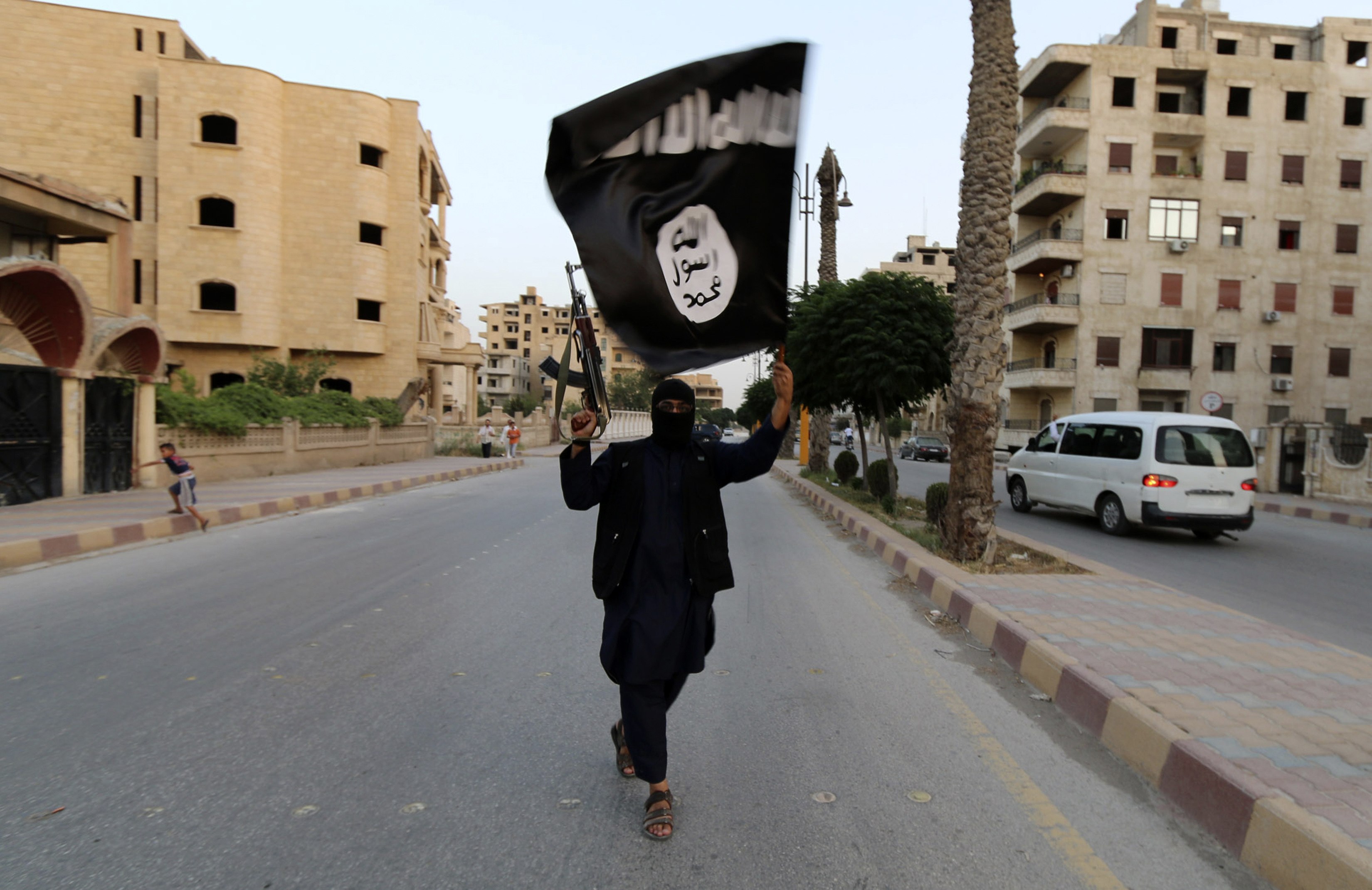 A member loyal to the Islamic State in Iraq and the Levant (ISIL) waved an ISIL flag in 2014.