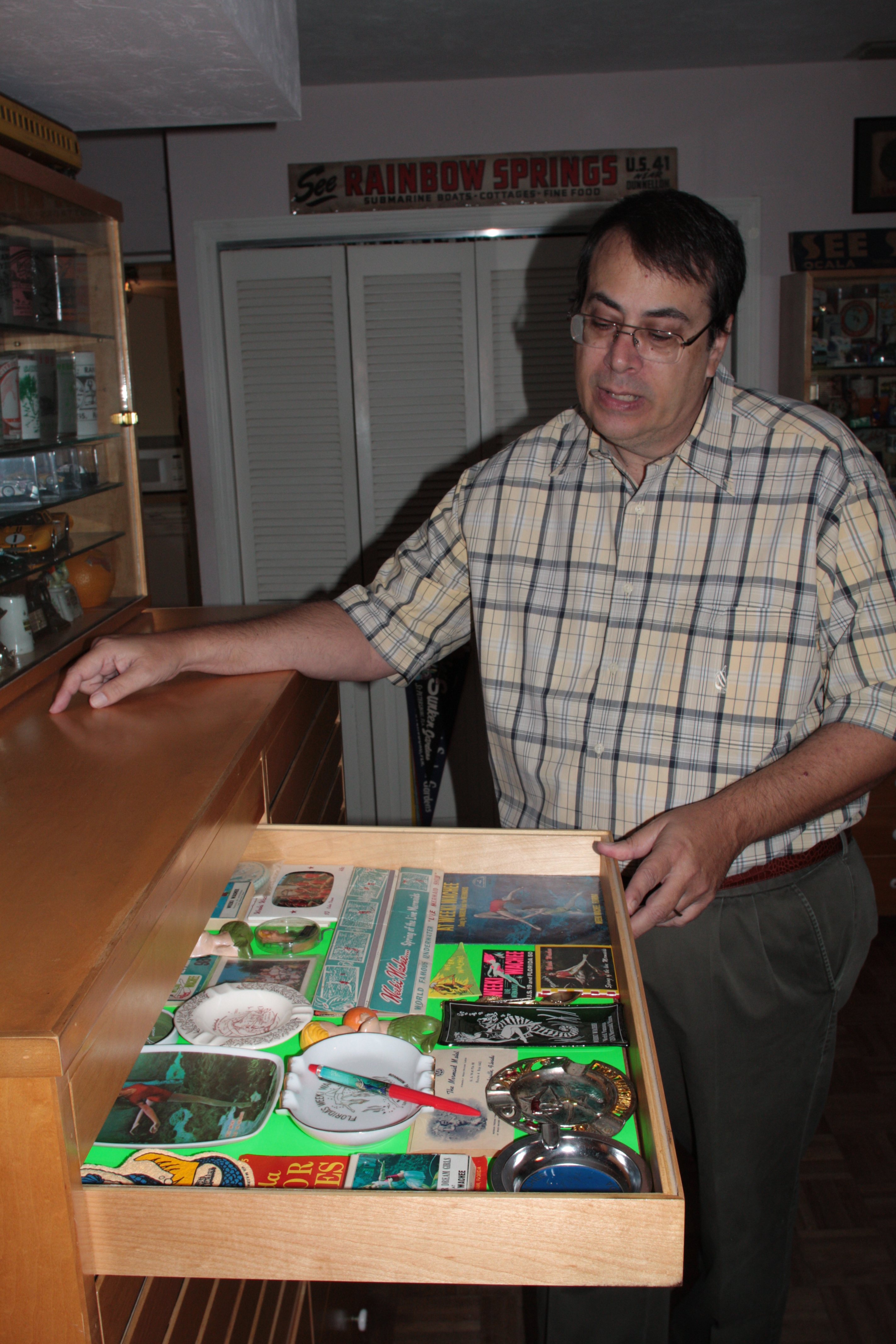 In St. Petersburg, Ken Breslauer opens one of the drawers of categorized items he has collected — more than 12,000 pieces of Florida memorabilia.