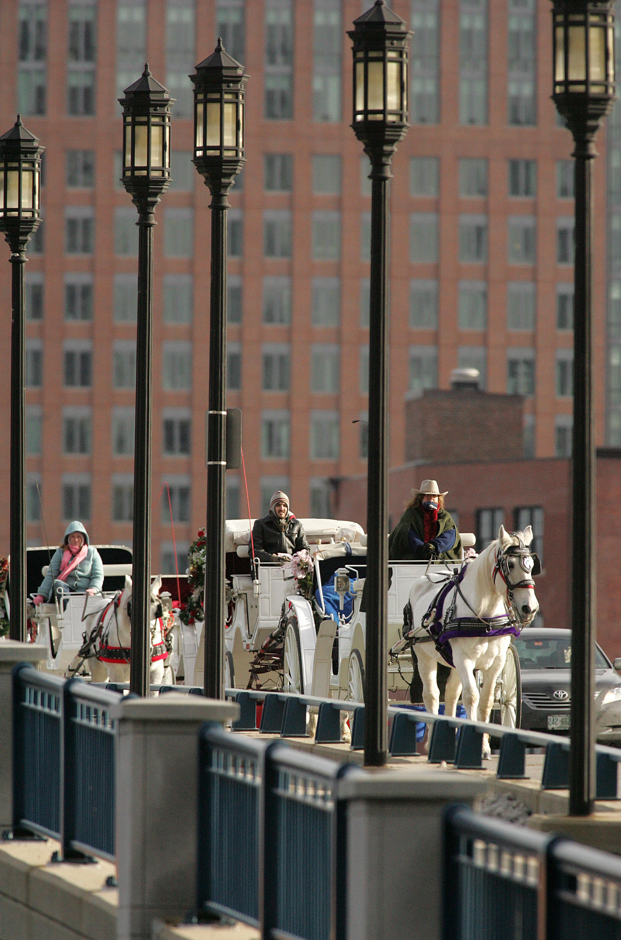 Horse-drawn carriages from the Bridal Carriage Company crossed the Seaport Boulevard bridge, which is paved, on their way to the Faneuil Hall area.