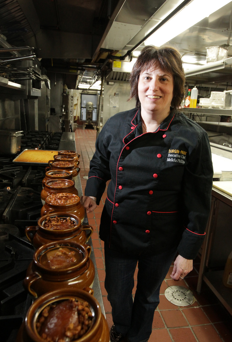 Durgin-Park chef Melicia Phillips preparing pots of baked beans with pork.