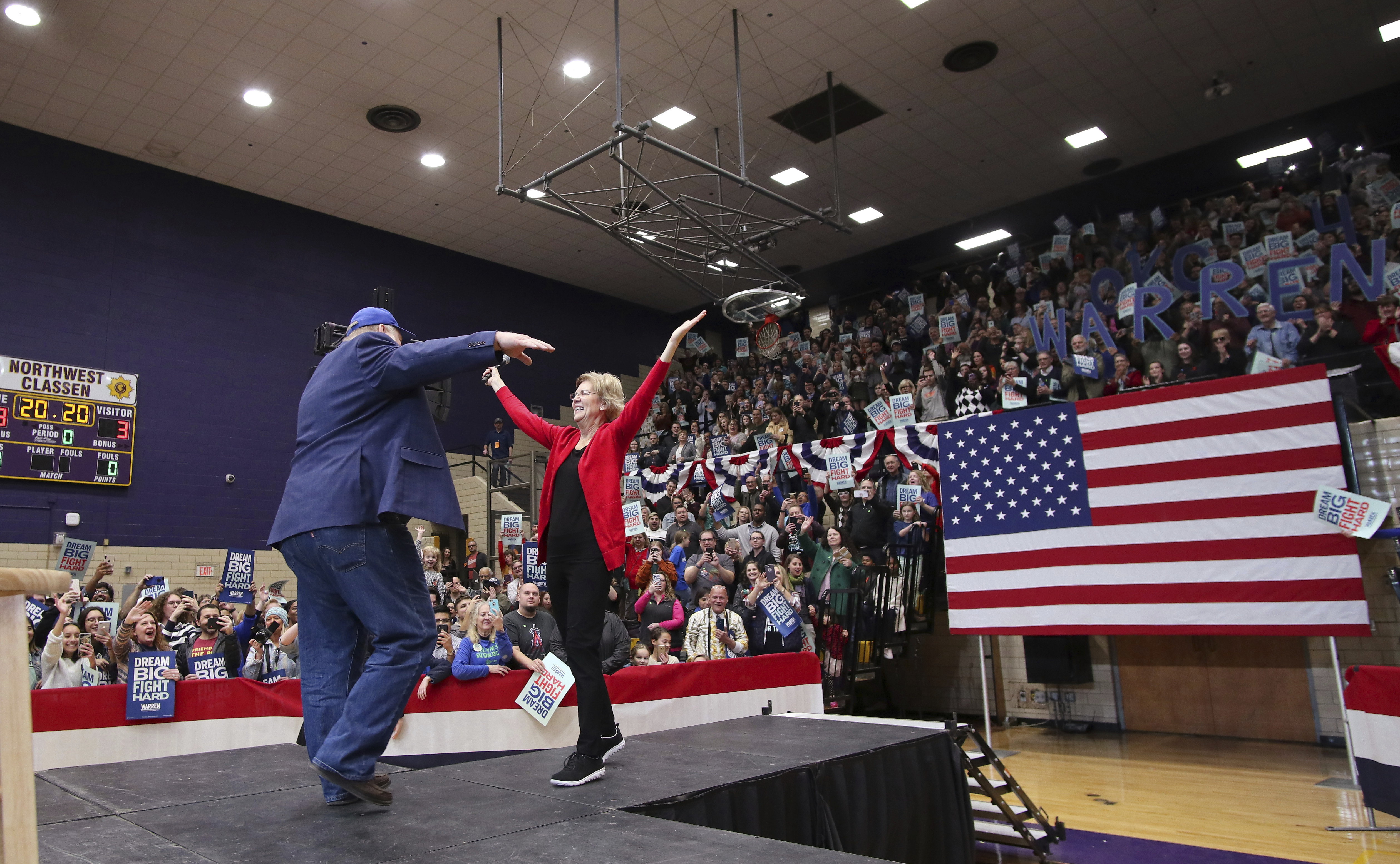 Elizabeth Warren is greeted on stage by her nephew Mark Herring during her campaign stop in Oklahoma City at Northwest Classen High School, her alma mater on Sunday.