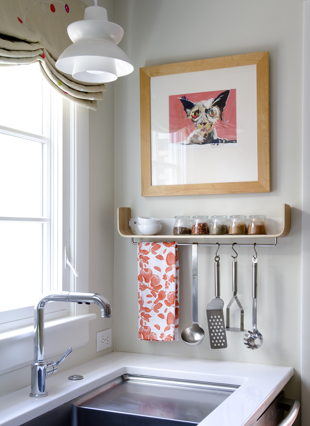 Swanson squeezed an 18-inch-wide dishwasher next to the sink. The white pendant light is from Rejuvenation and the framed cat print came from a sidewalk sale at Montserrat College of Art.