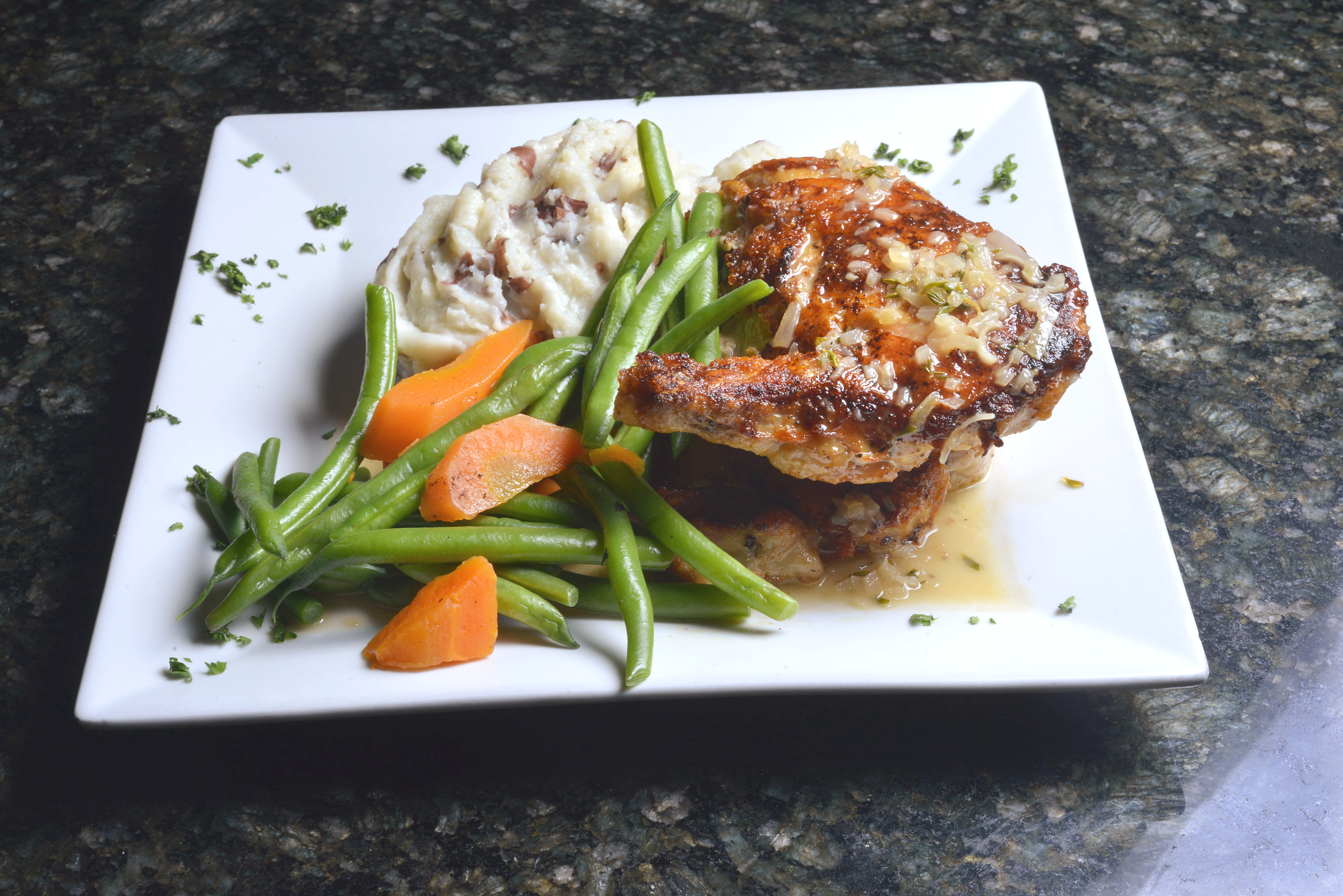 Chicken is seared under a brick and grilled.