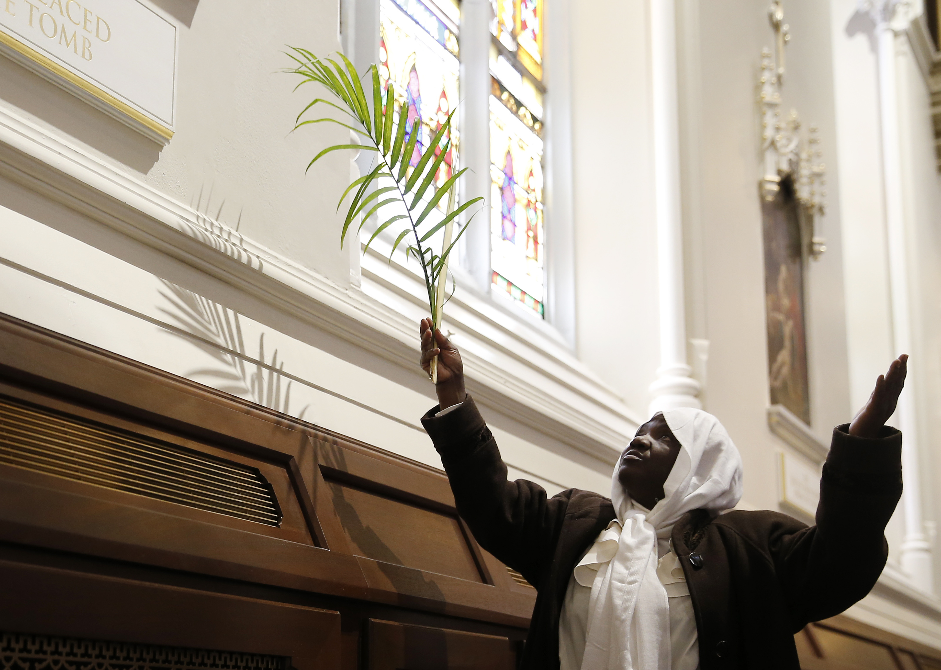 Darlene Price of Somerville held aloft her palm as she prayed during a Palm Sunday Mass at the newly reopened Holy Cross Cathedral.