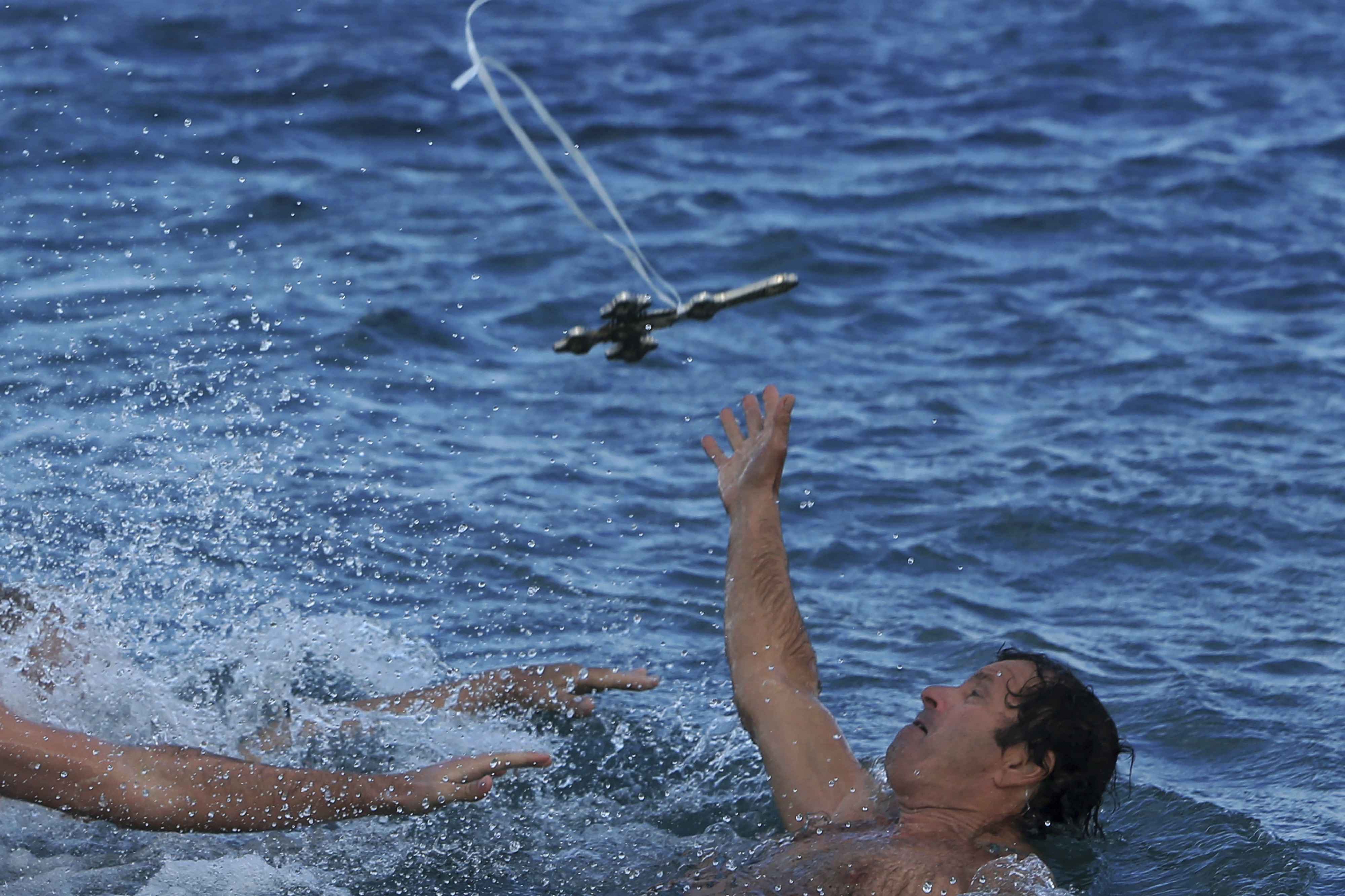 A swimmer dove to try to catch the thrown cross during a ceremony on the island of Cyprus.