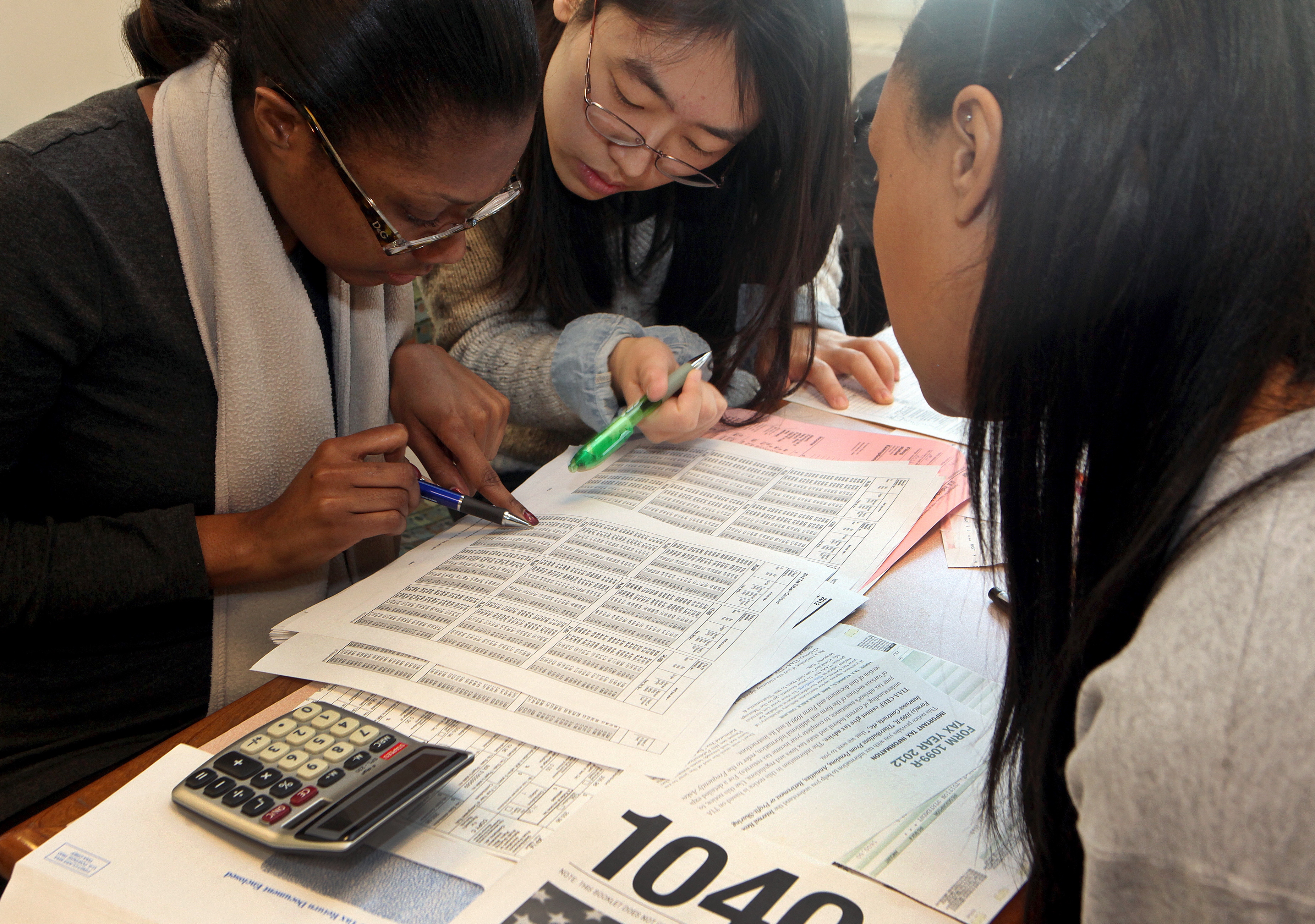 Volunteers Carla Daley (left) and Ziyi Lou (middle) helped Kijana Rose (right) with her taxes, using the paper forms.