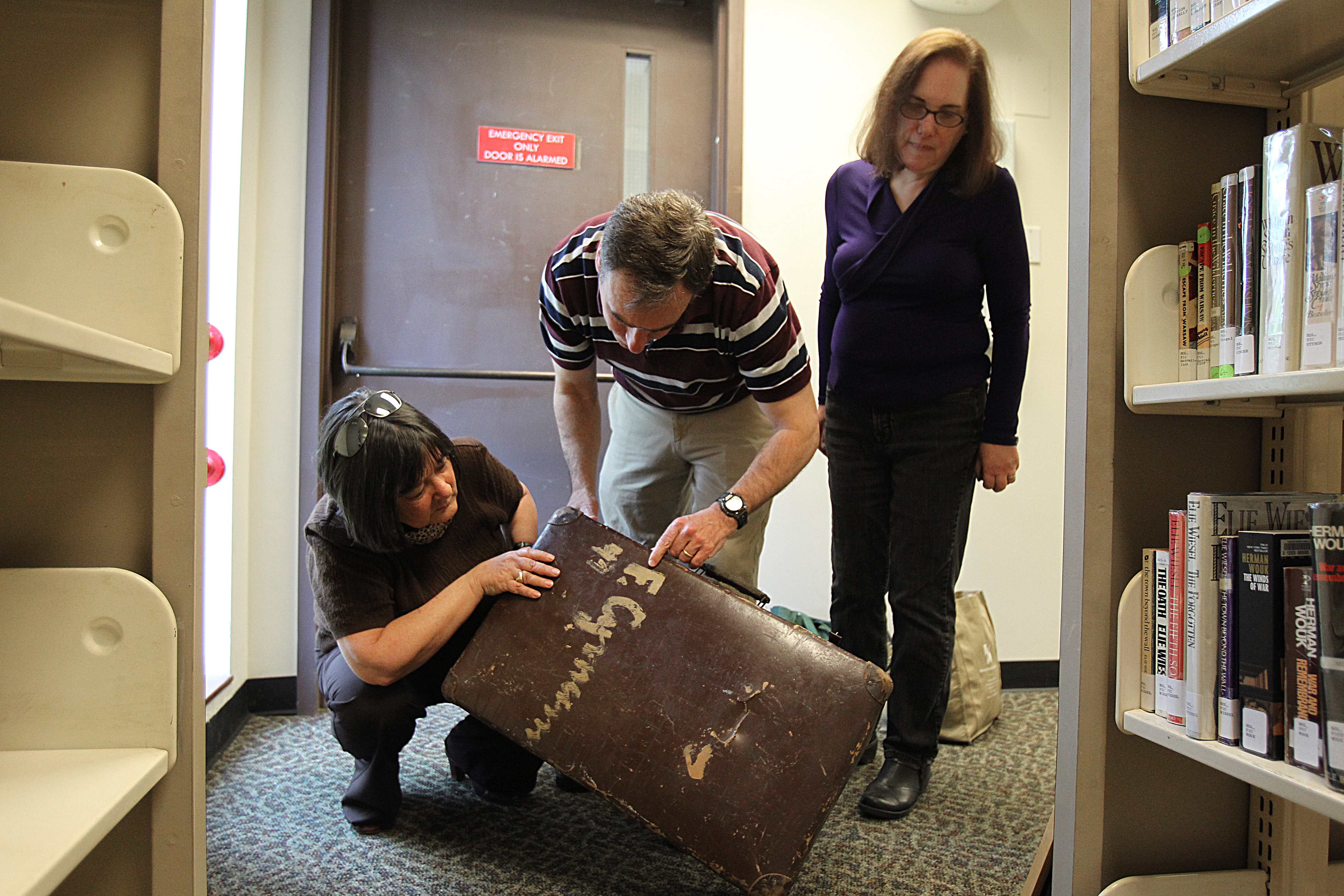 Left to right, Margo Steiner, Chris Mauriello, and Harriet Wacks examined a suitcase donated to the center.