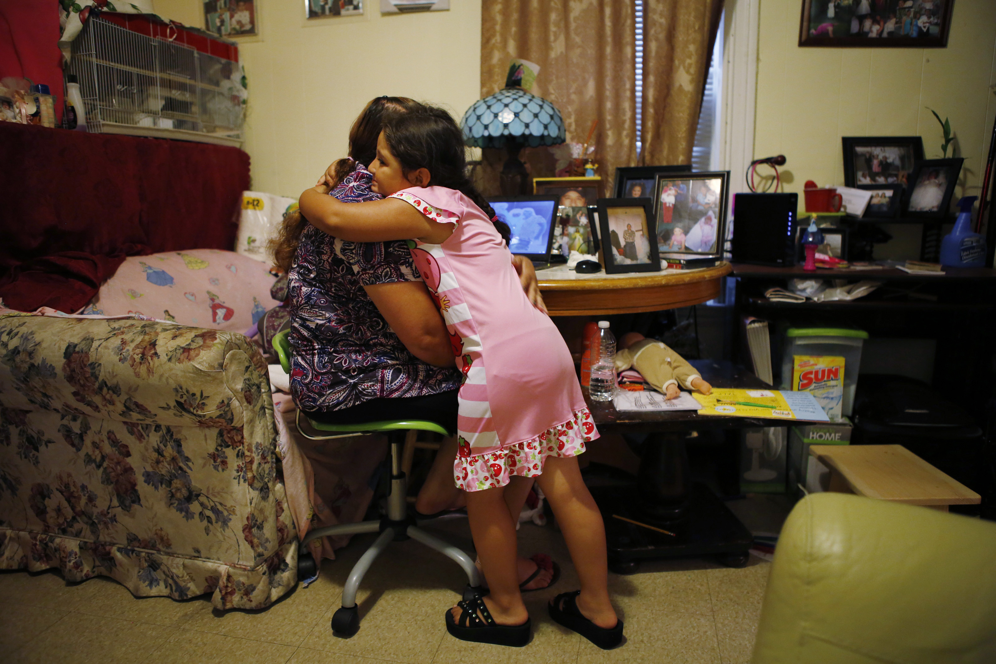 Petrona Interiano of East Boston is embraced by her daughter Nataly, 5, after she began crying while talking about her brother Santos.