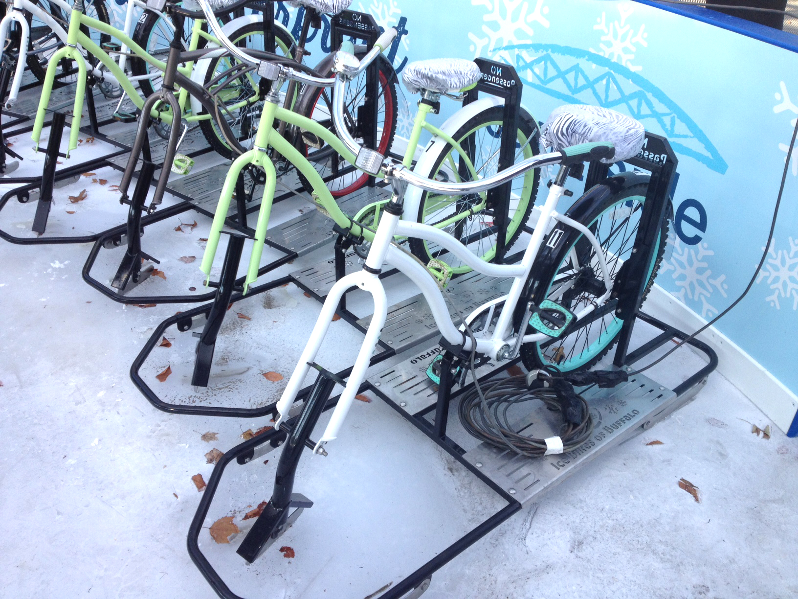 A skate blade replaces a front wheel on an ice bike.