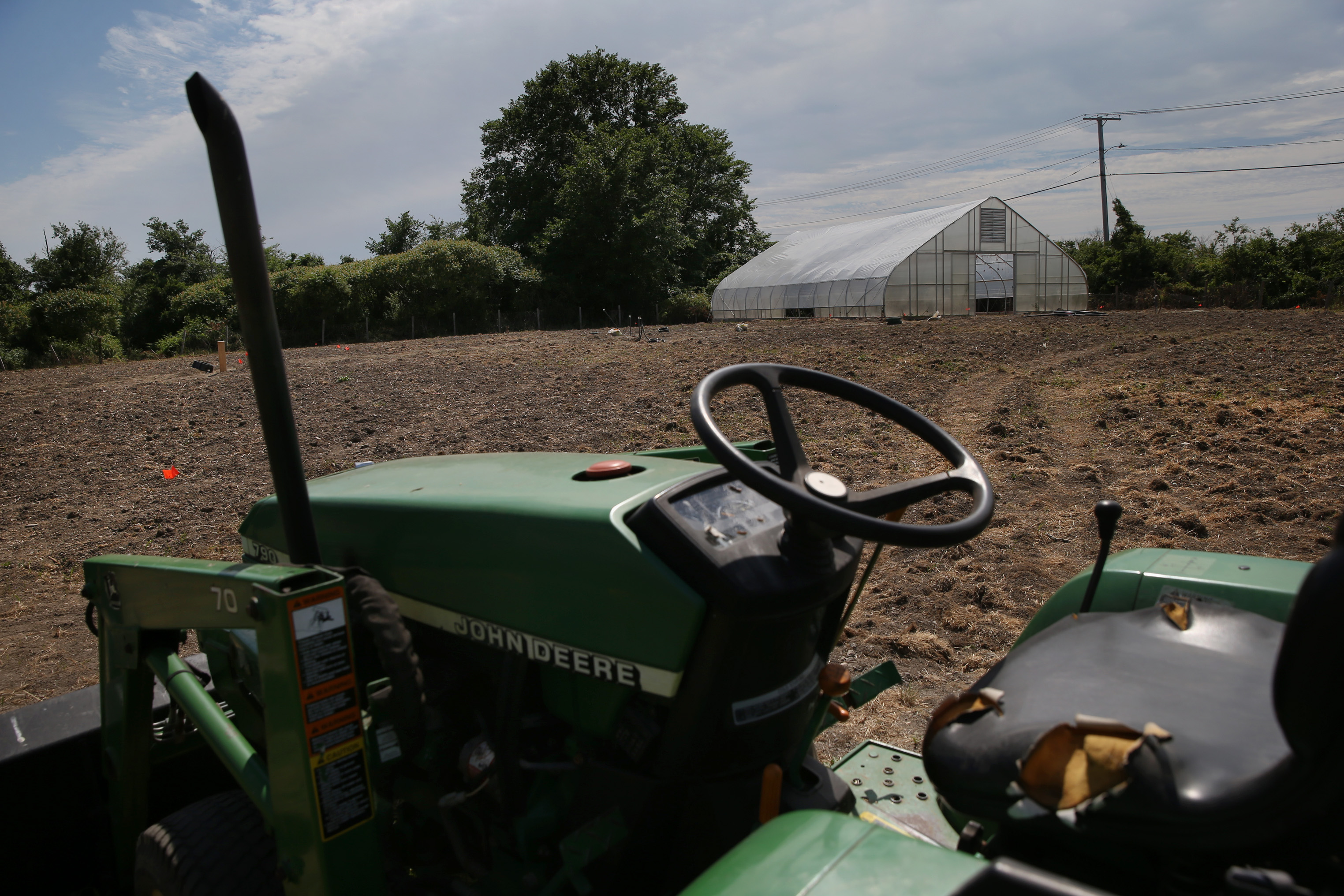 A tractor and greenhouse are pictured on the farm.