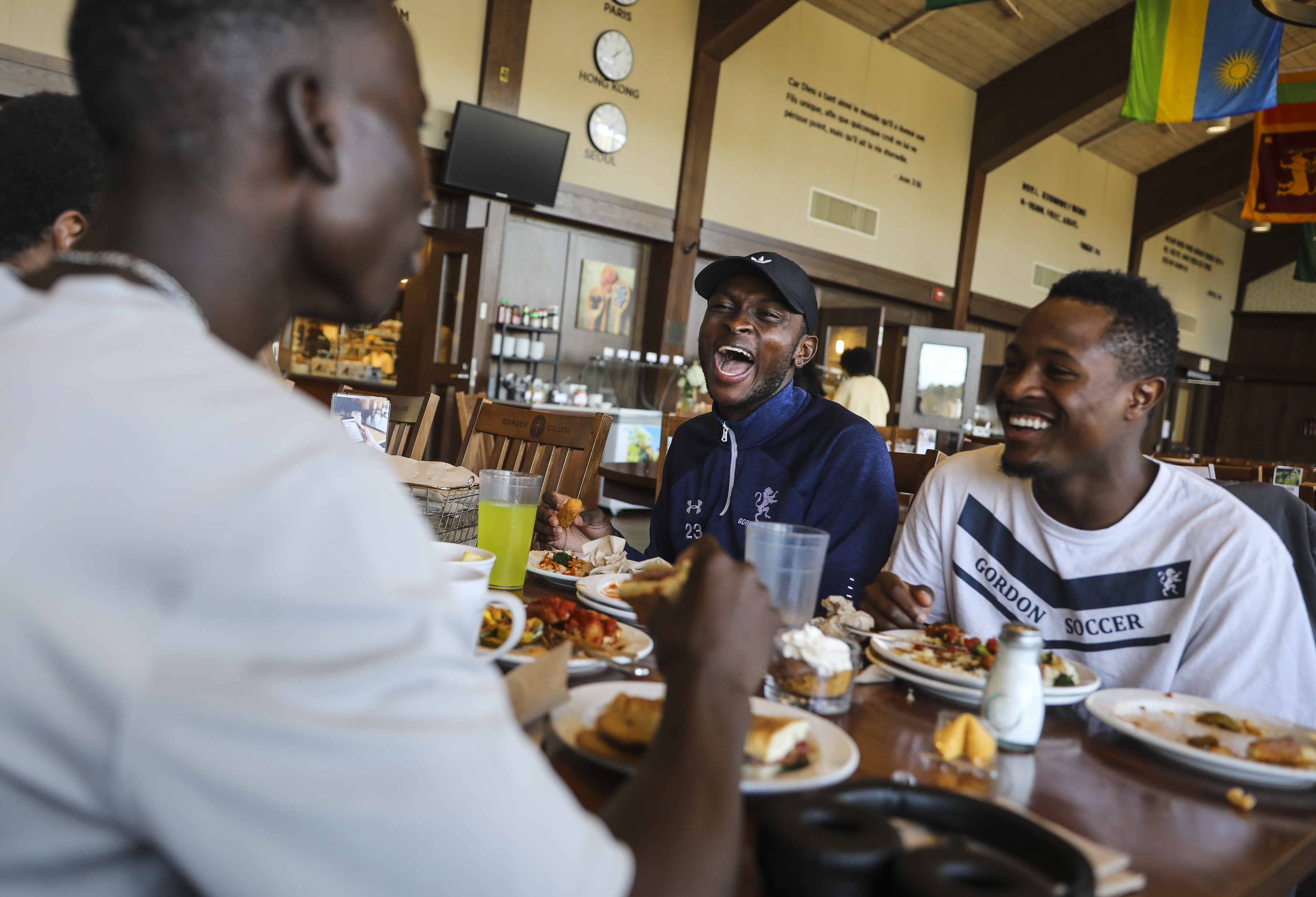 Roddy Ngolomingi (middle) shared lunch and laughs with soccer teammate Simba Dimbo (right) on the campus of Gordon College.