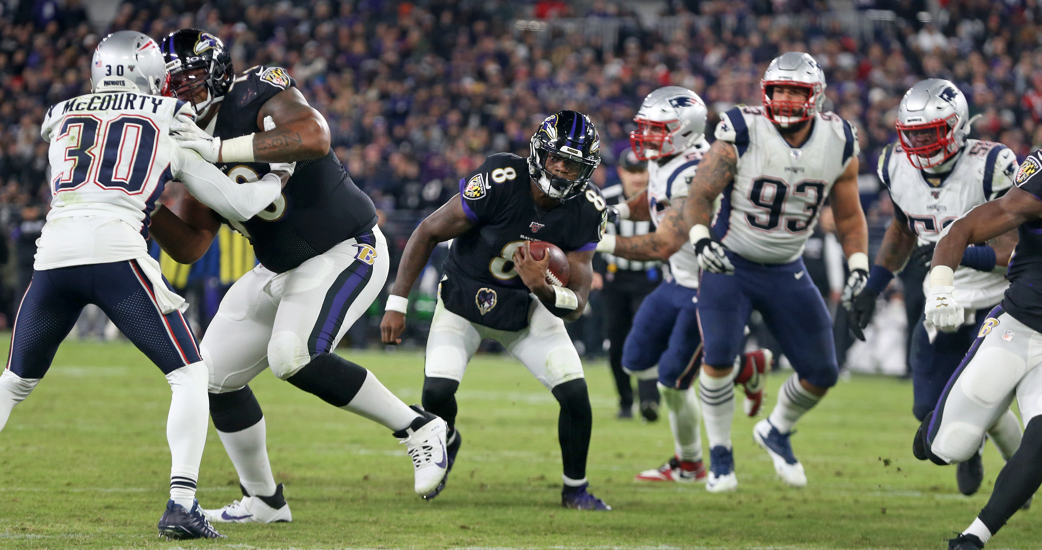 Lamar Jackson heads for a gap as he sets up the Ravens’ final touchdown of the game on Sunday in Baltimore.