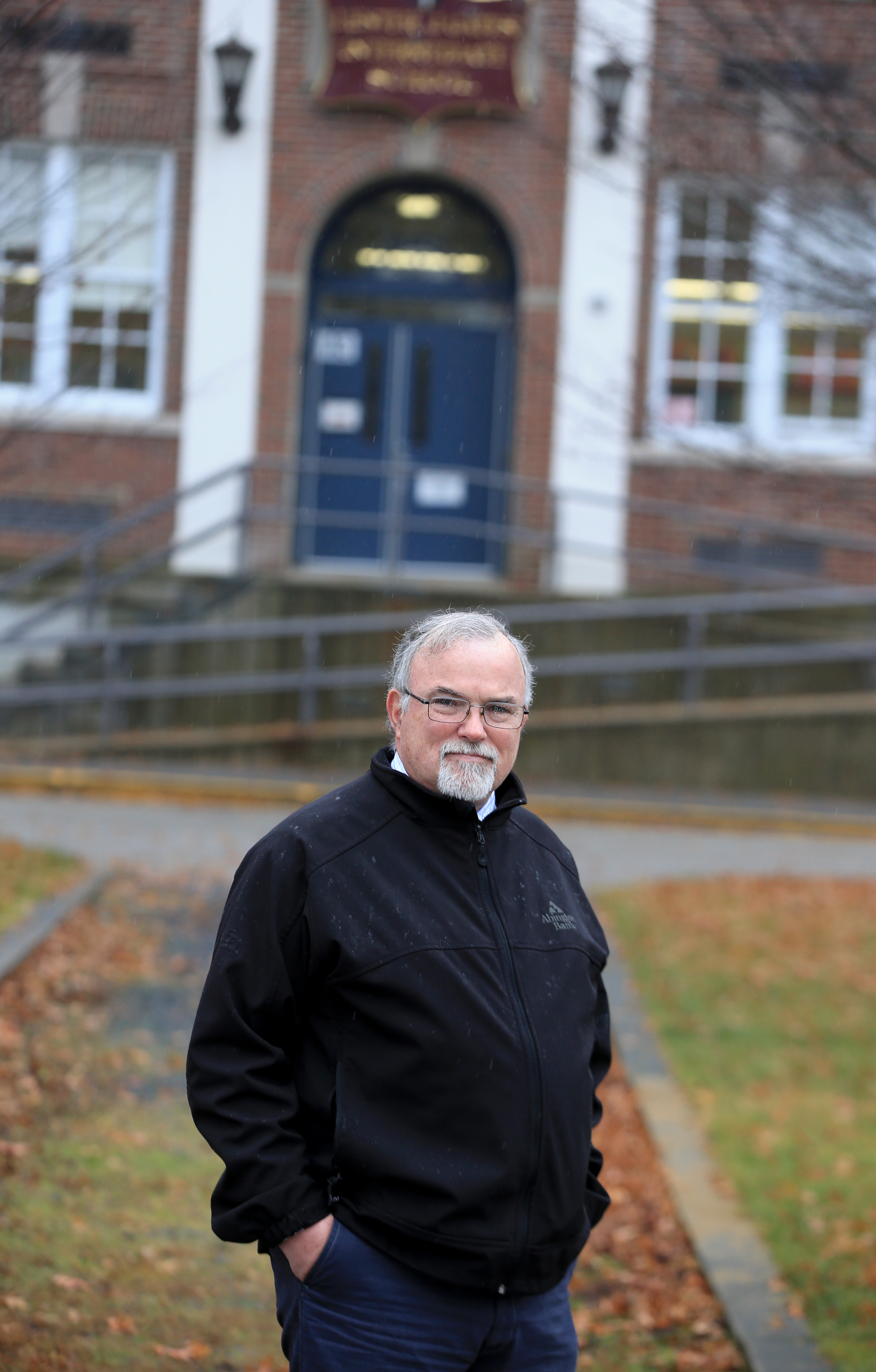 Paul Donlan in front of Gates Intermediate School in Scituate. His job is to oversee the school’s compliance with federal asbestos laws.