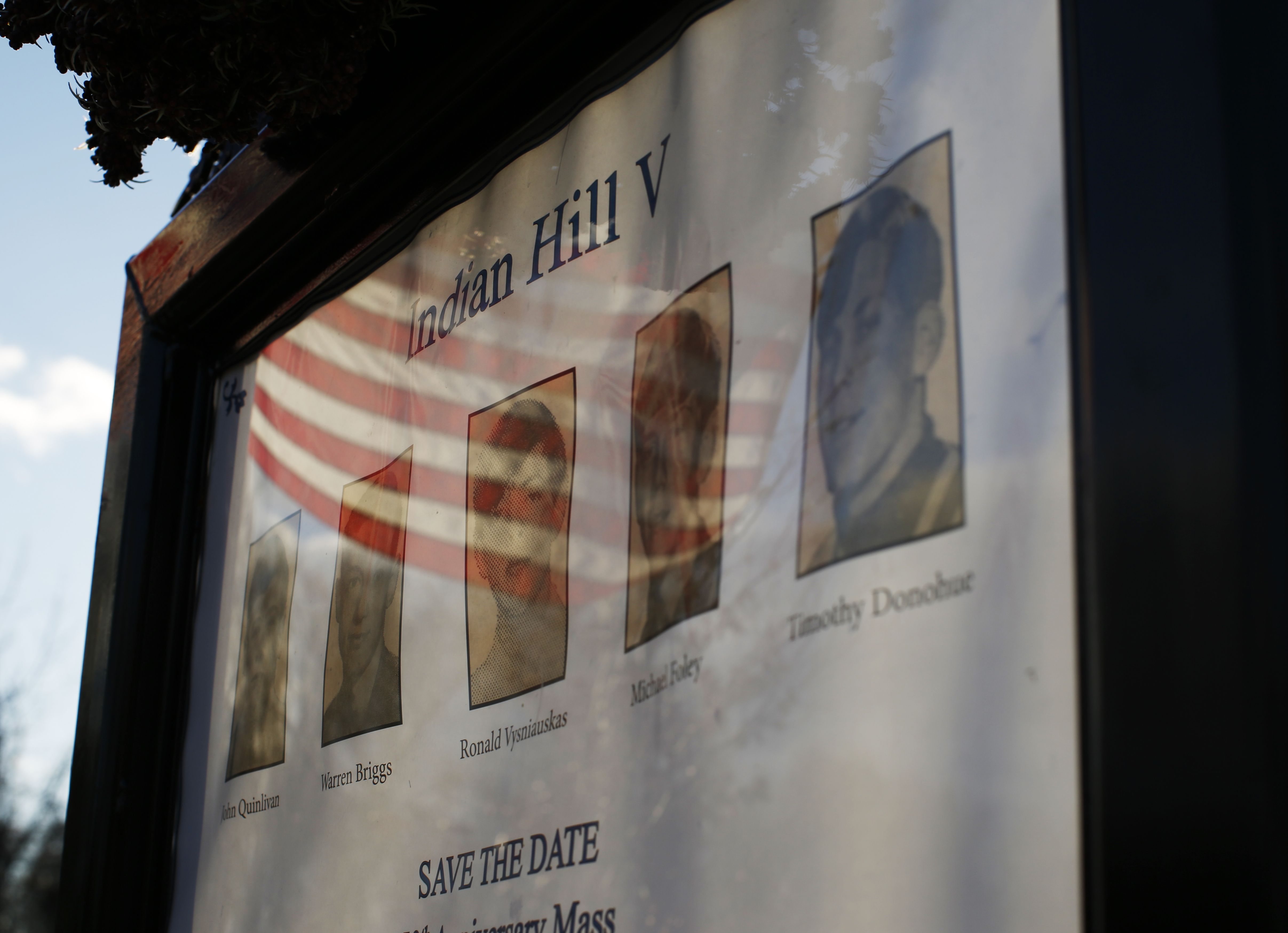 A flag at half-staff was reflected on a memorial that honors the five teenage boys who died in the Indian Hill fire 50 years ago.