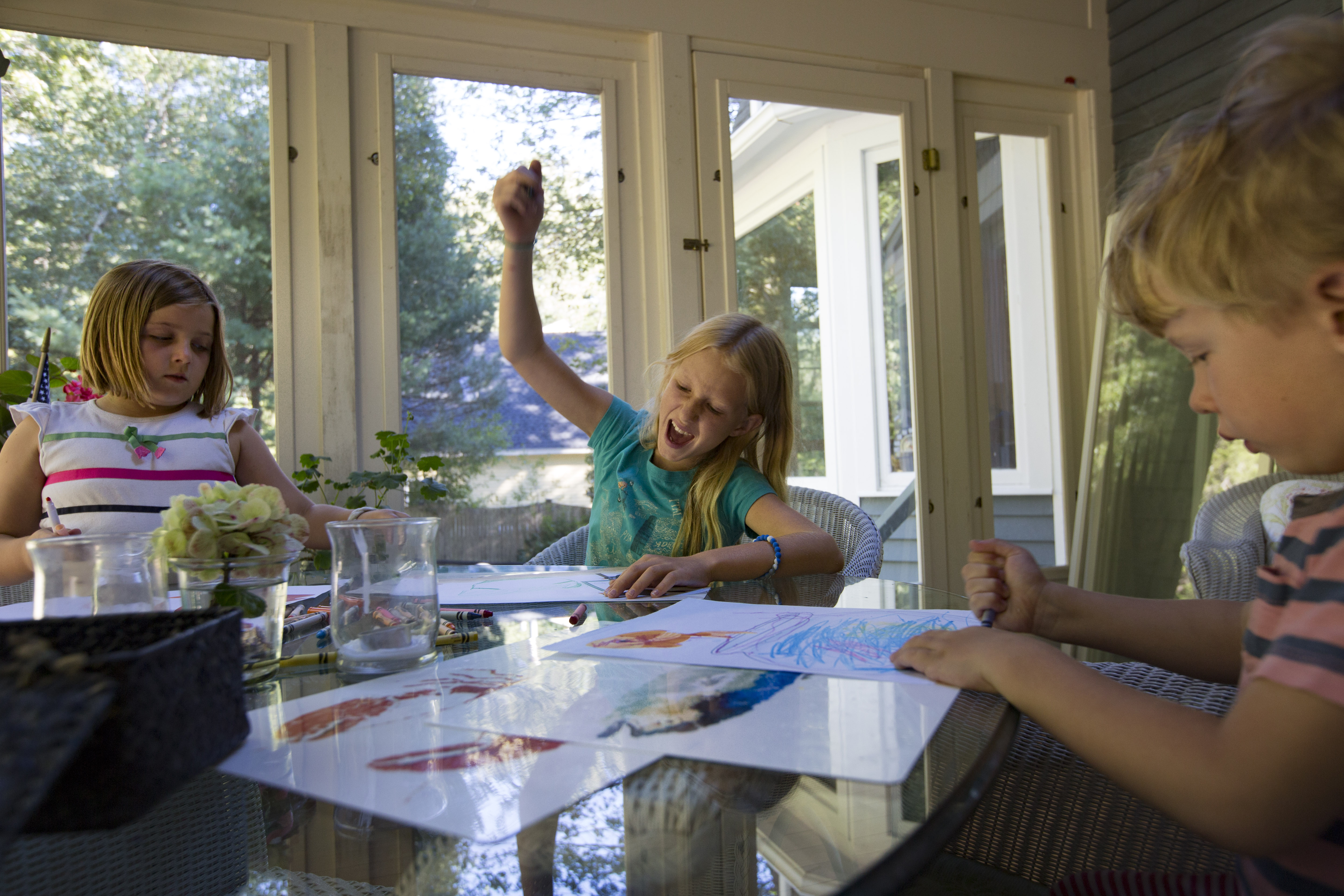 Ava Dennesen drew pictures with her neighbor Ellie Virden, left, after school. At right is Eli Dennesen.