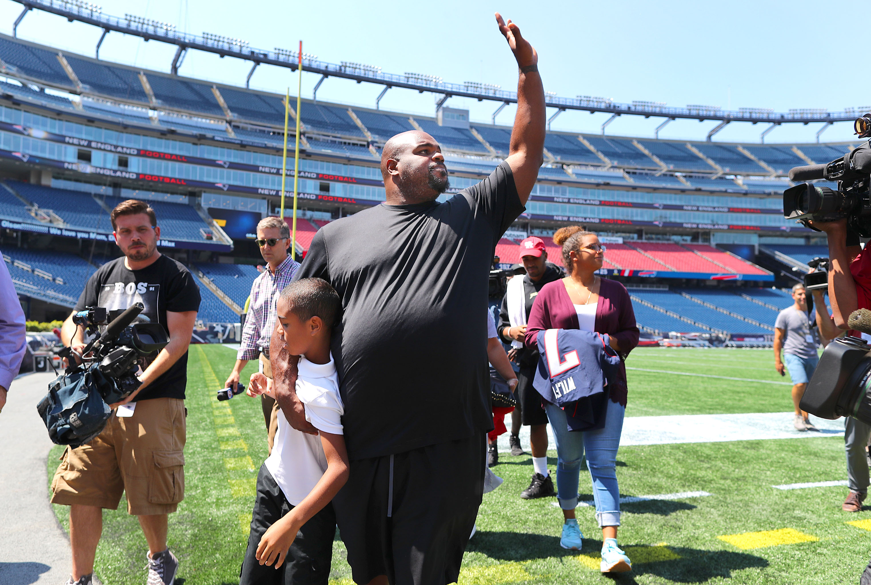 Wilfork walked with his son David, 8, as he waved to people who cheered him while he walked the field in Gillette Stadium after the news conference.