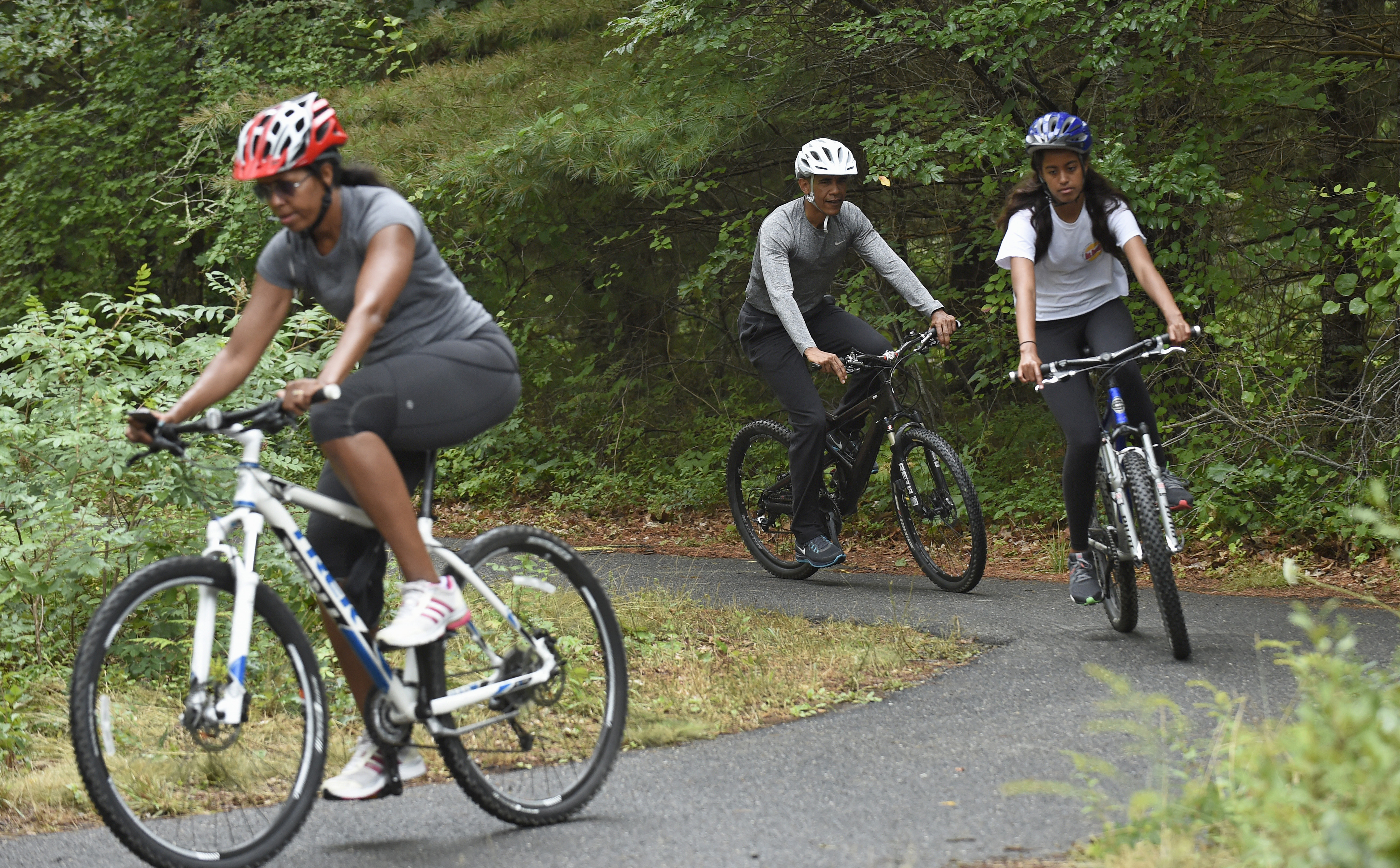 Then-President Barack Obama, his daughter, Malia (right), and first lady Michelle Obama (left) rode bikes in West Tisbury on Aug. 22, 2015.