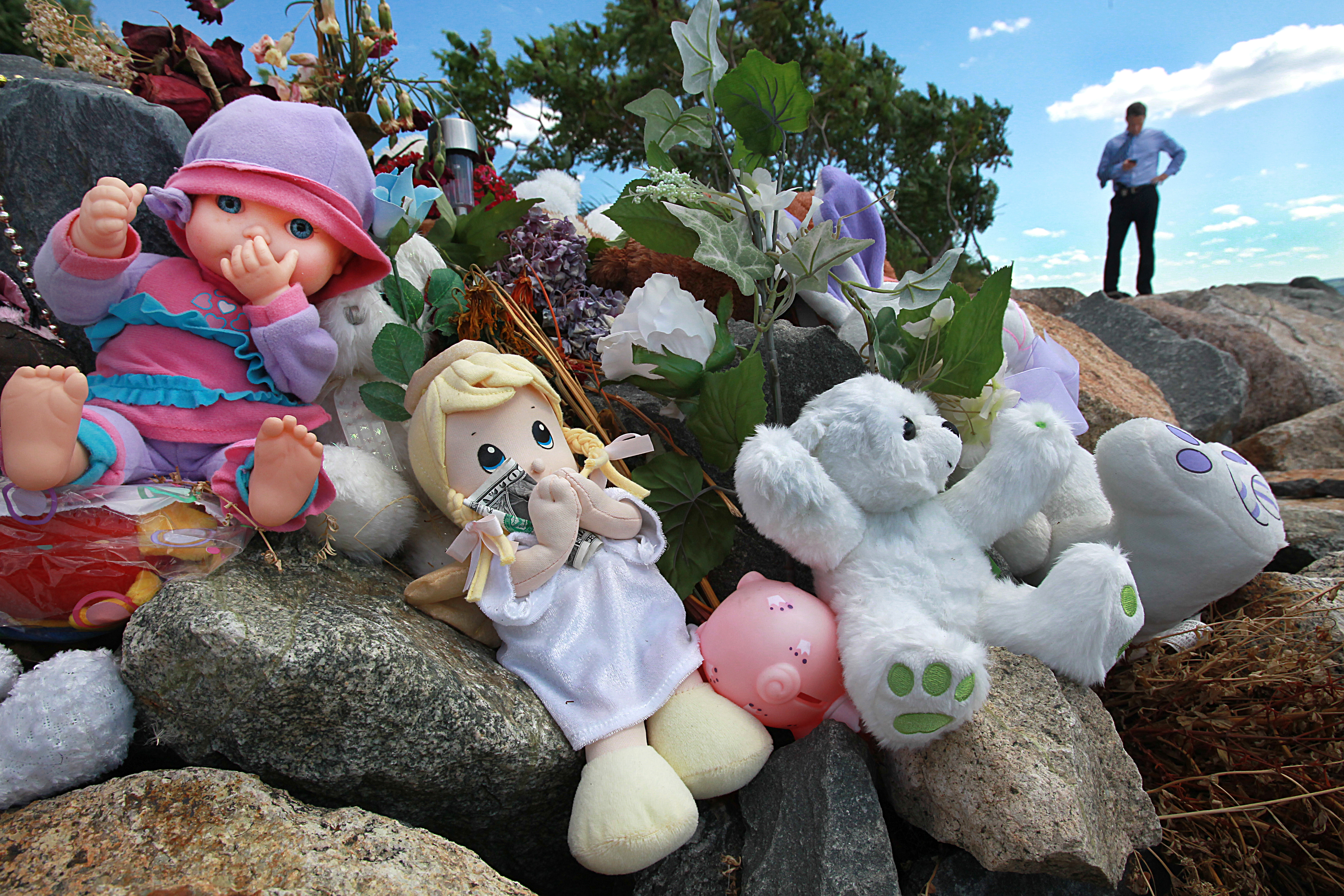 Stuffed animals and dolls are part of a memorial on Deer Island.