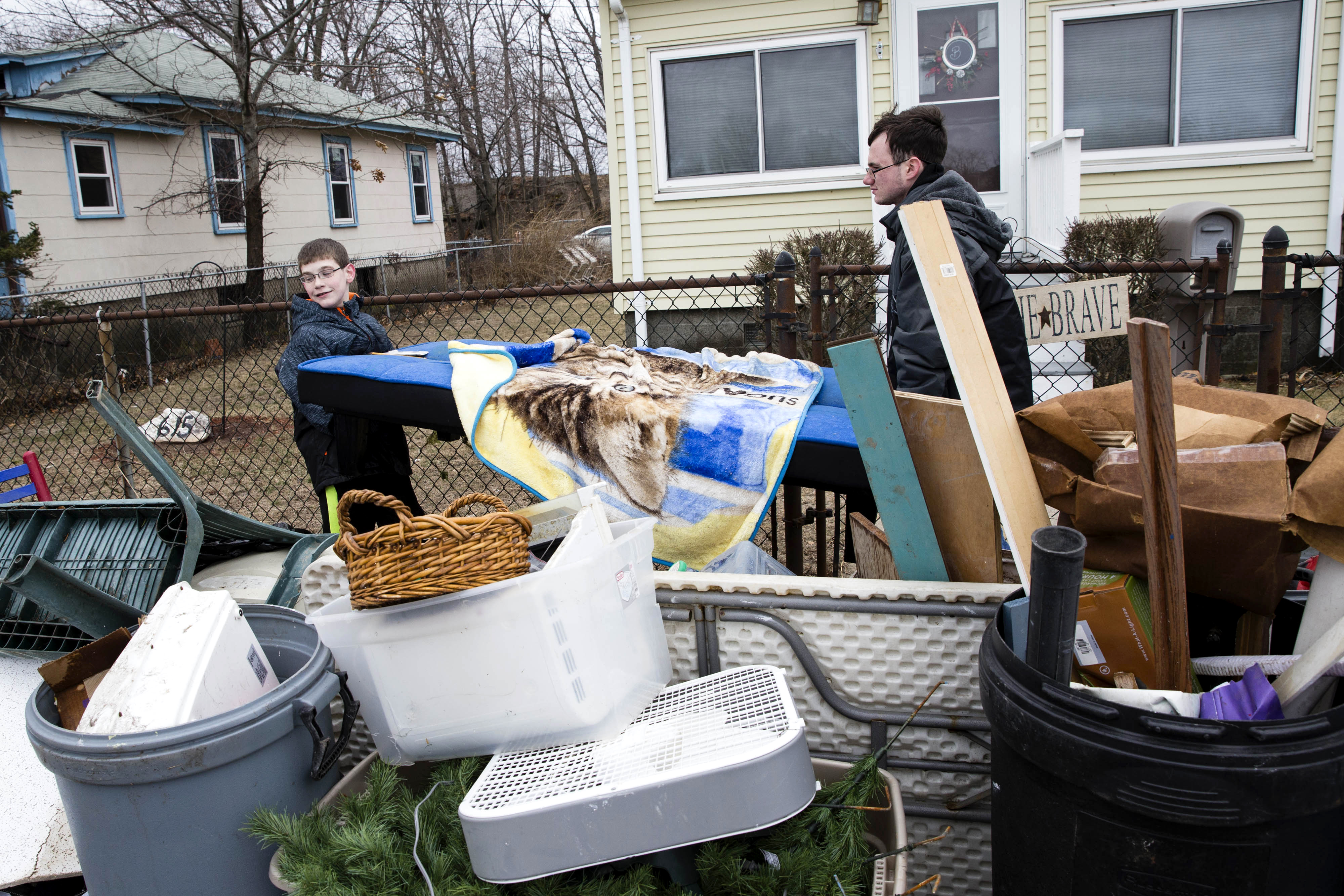 Walter (left) and Ben Bardon piled flood-damaged belongings outside of their family’s Quincy home on Monday.