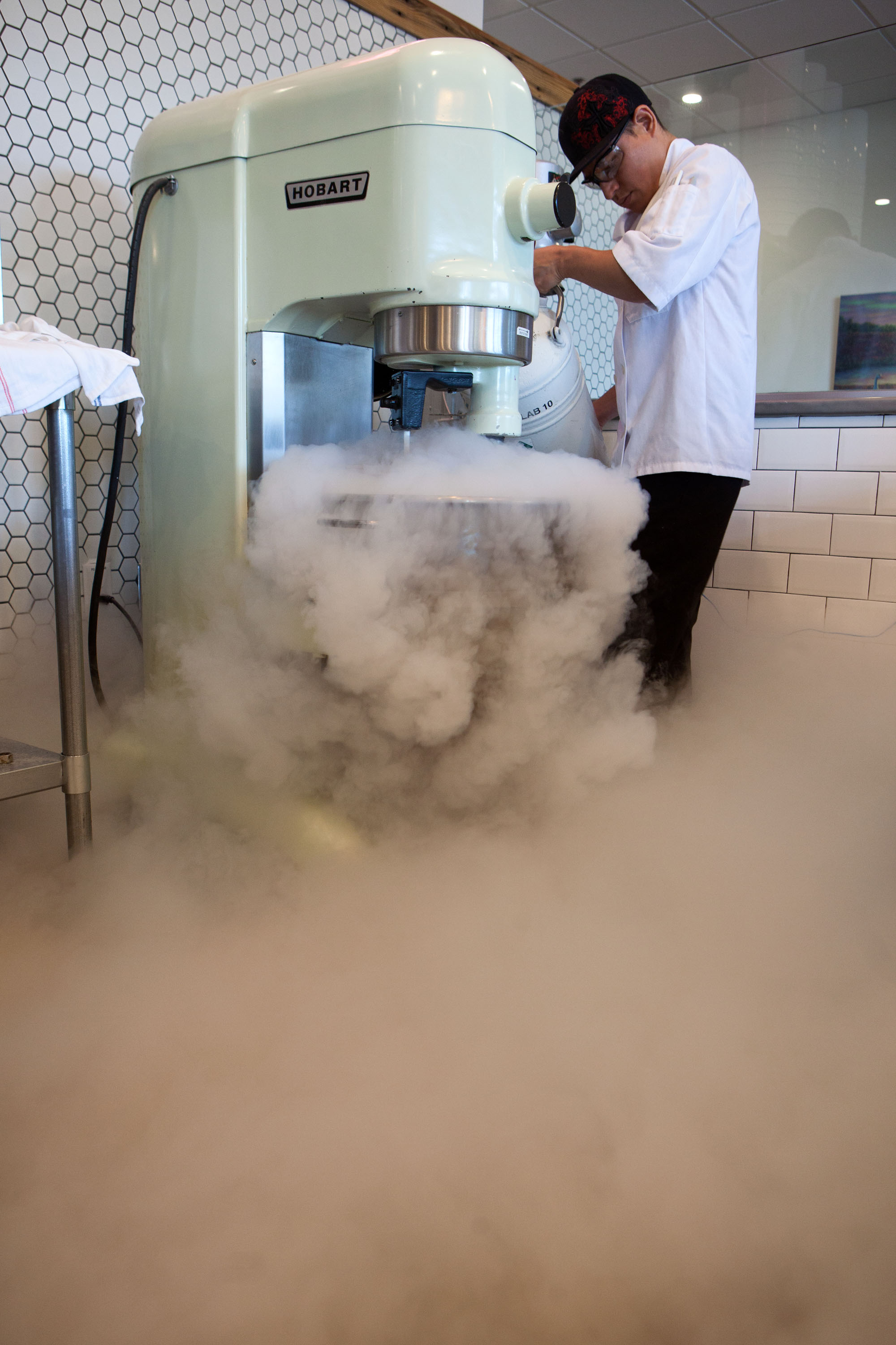 Folks line up for treats at New City Microcreamery, where they watch worker Imeldo Gomez use liquid nitrogen to make ice cream in the open kitchen.