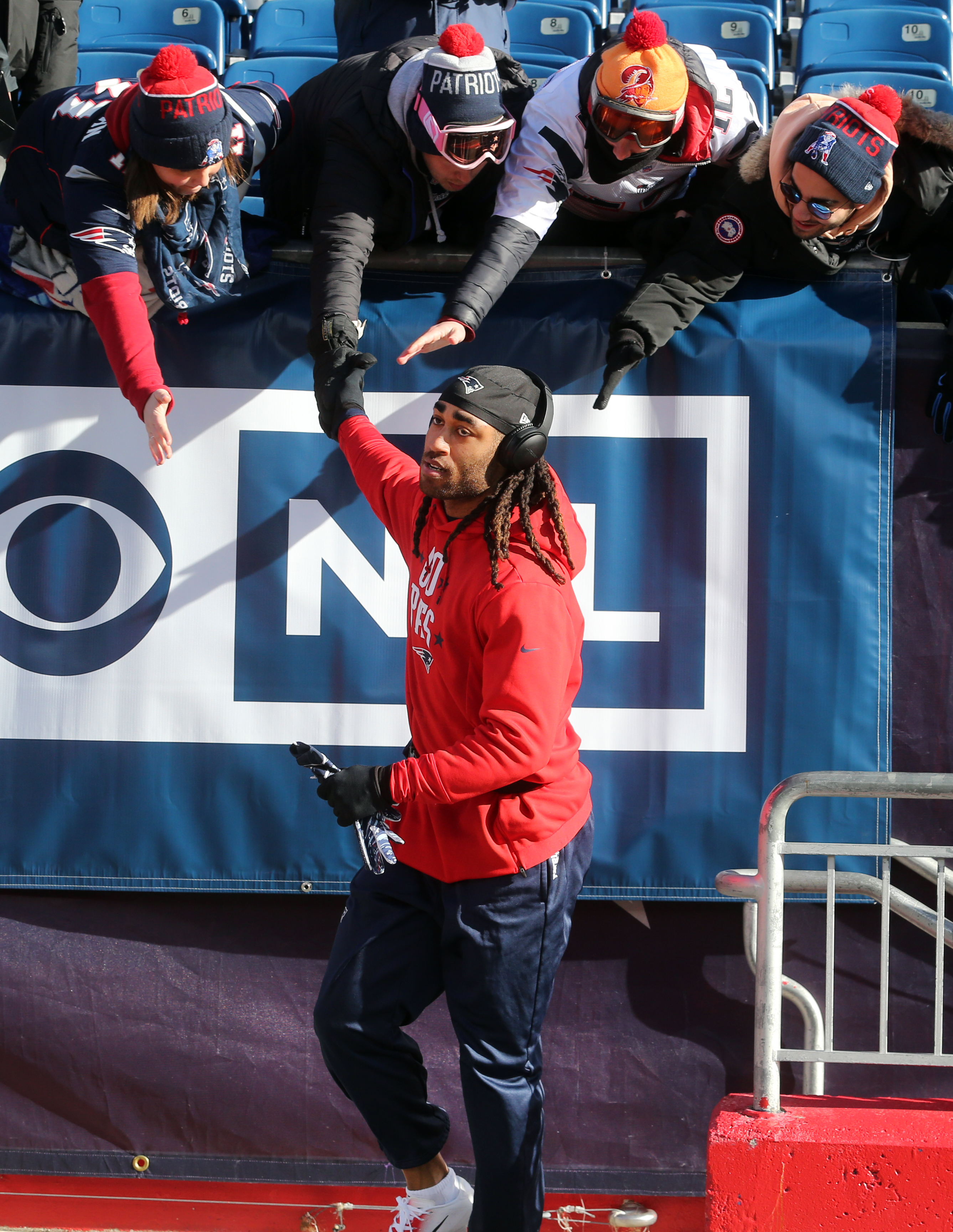 Patriots cornerback Stephon Gilmore high fives fans before the game.