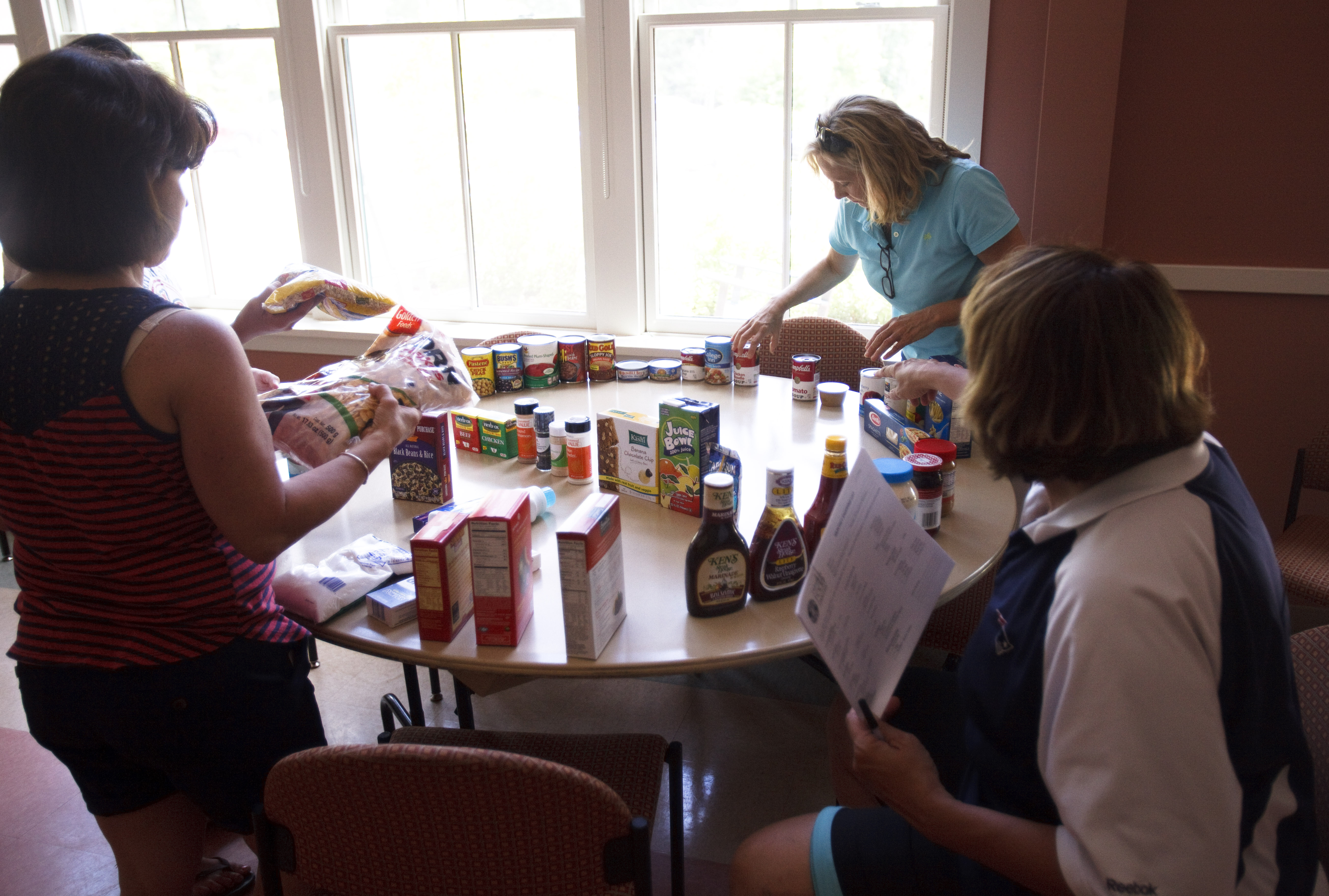 Patricia Crowley, Lisa Buccella, and Cindy Fontaine set up a table to display available food at the Franklin Senior Center.