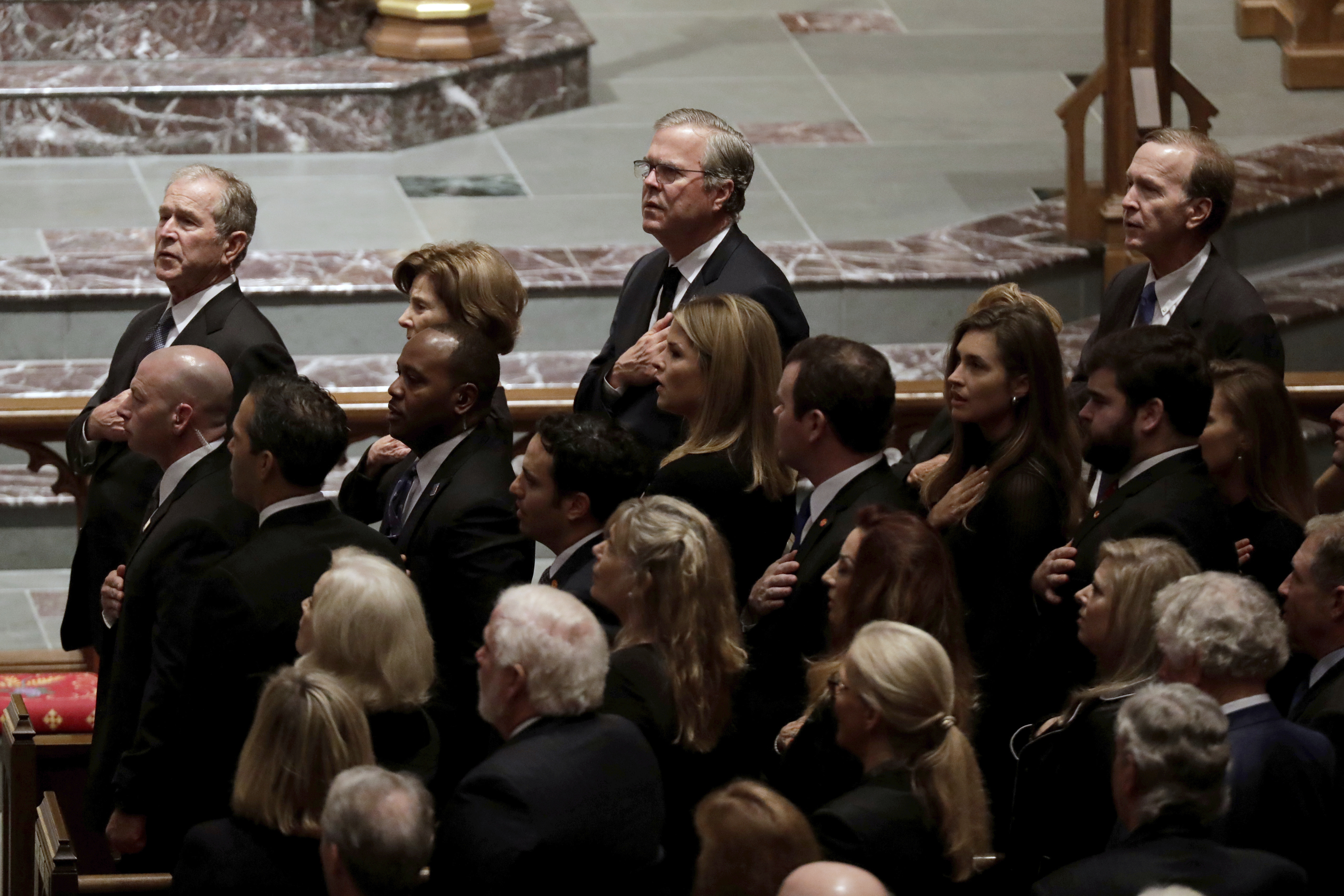Former President George W. Bush (left) and his brothers former Florida Gov. Jeb Bush and Neil Bush sang during a funeral for former President George H.W. Bush.