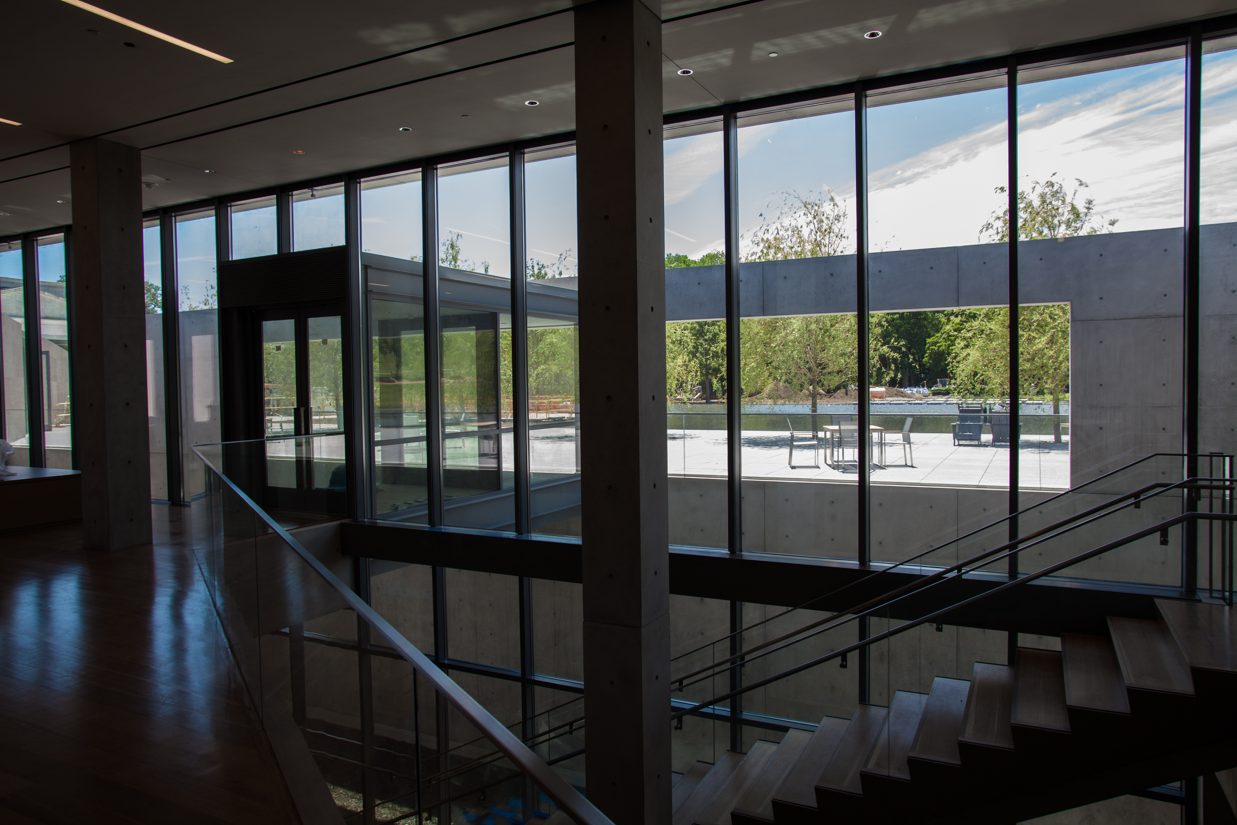 From inside the Center, one sees the pool beyond a sitting area, and stairs to galleries below ground.