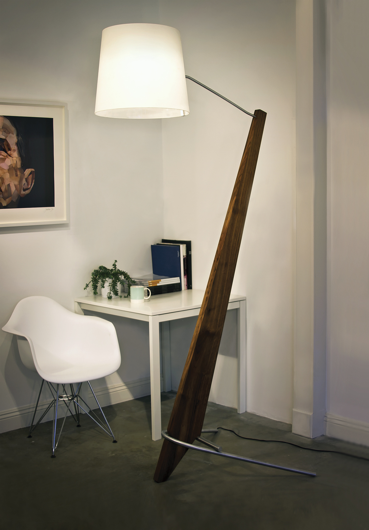 A tall floor lamp with slanted walnut base from California lighting company Cerno.