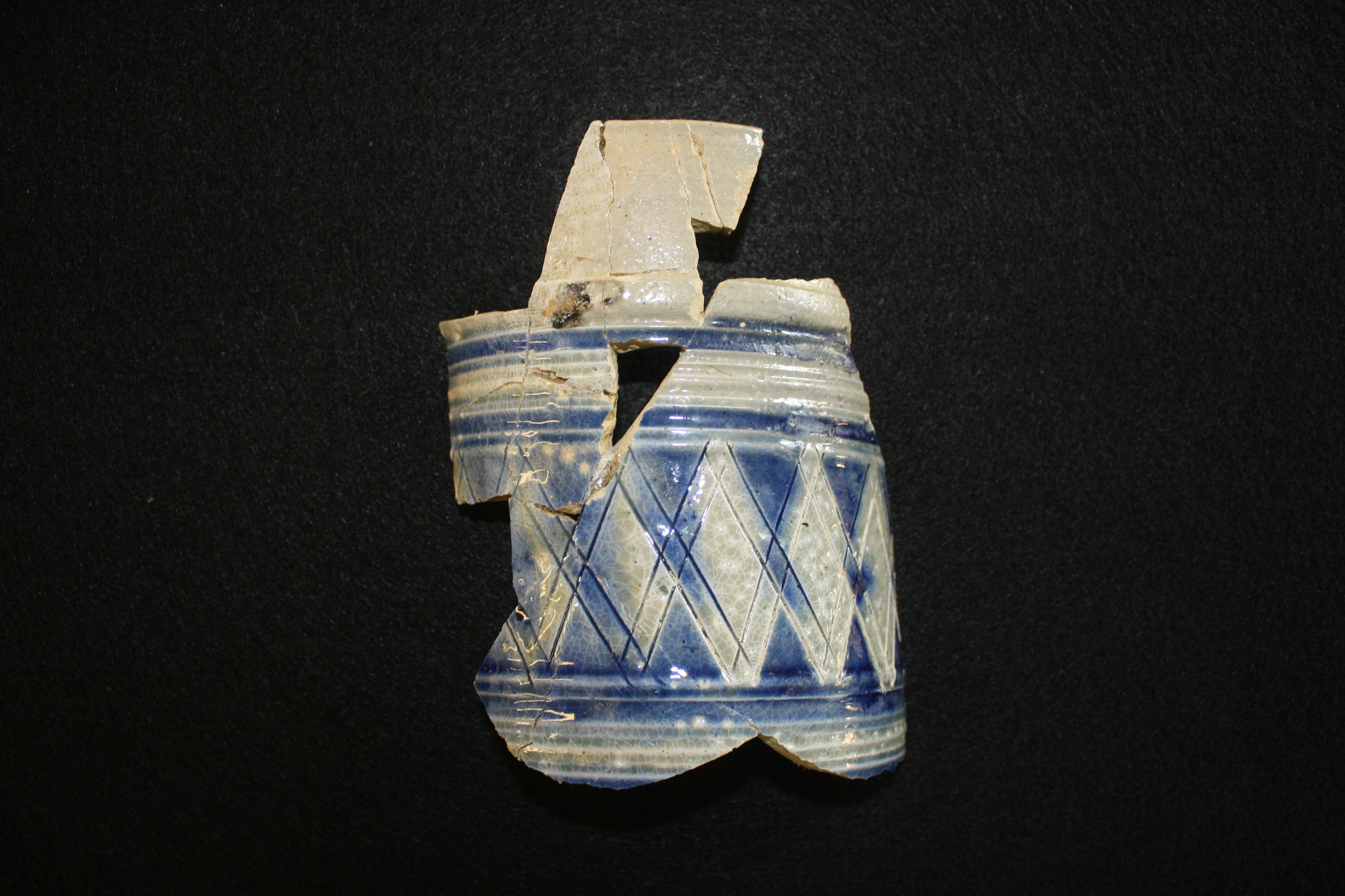 This is arguably the finest example of ceramics found at the site, discovered at cellar floor level, four feet below grade. It is an ale flagon about six inches high made of Westerwald stoneware, ca. late 17th - early 18th century.