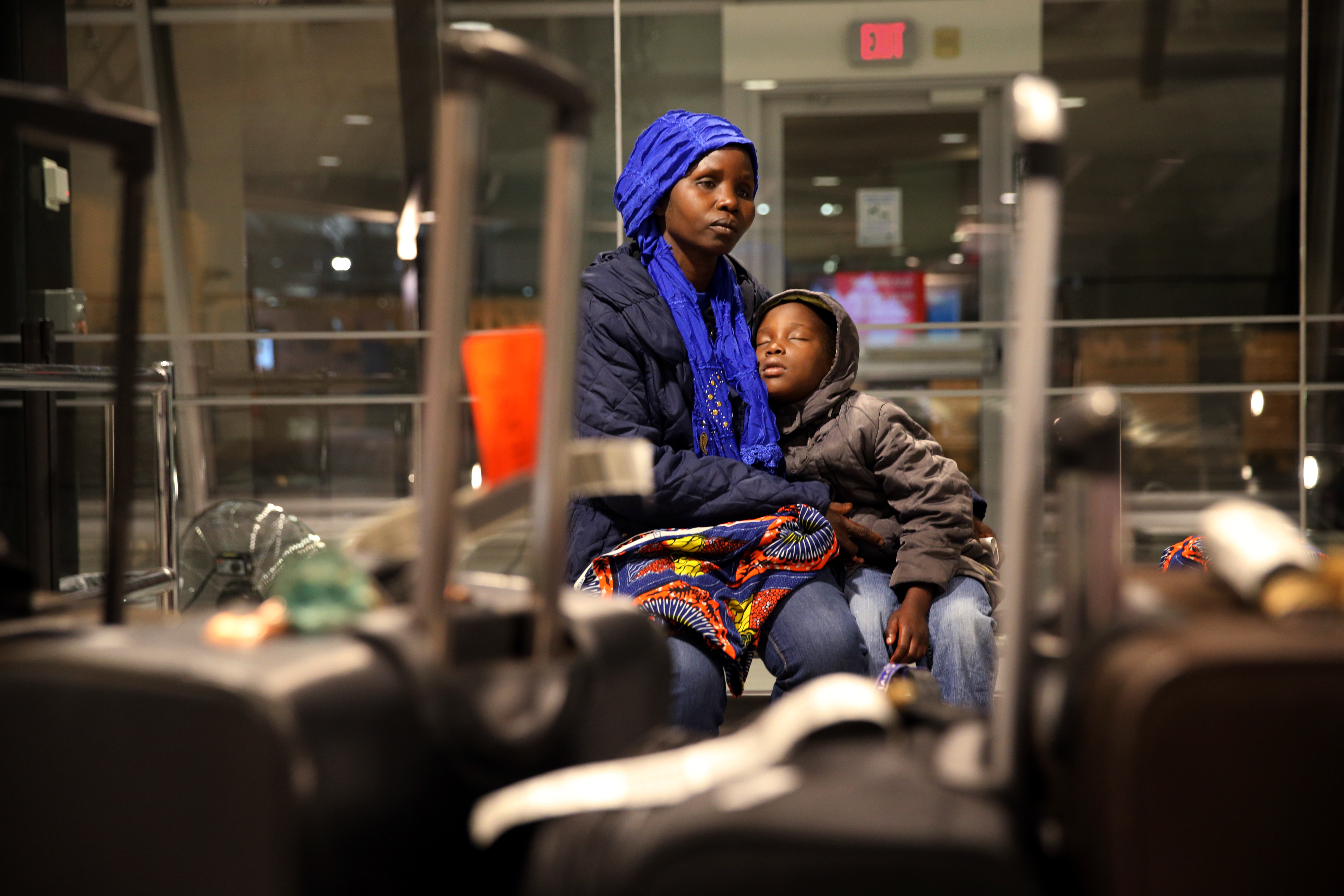 Vanisi Uzamukunda comforted her sleepy daughter, Sarah, 7, while waiting for their baggage at the Manchester–Boston Regional Airport in Manchester, N.H.