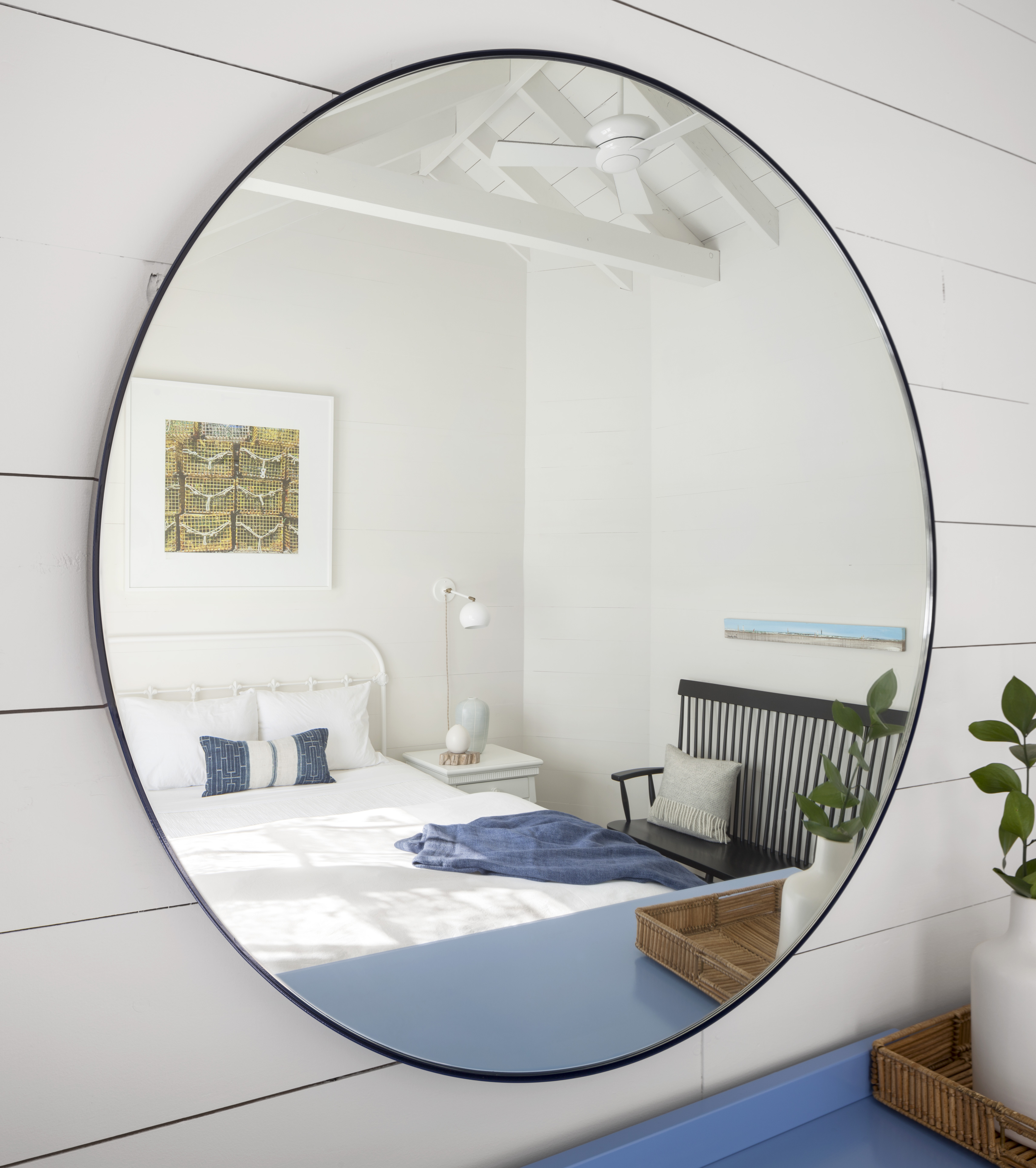 In the guest room, the high-back bench from Rejuvenation looks like a family heirloom. The Schoolhouse Electric & Supply Co. Isaac sconces are adjustable.