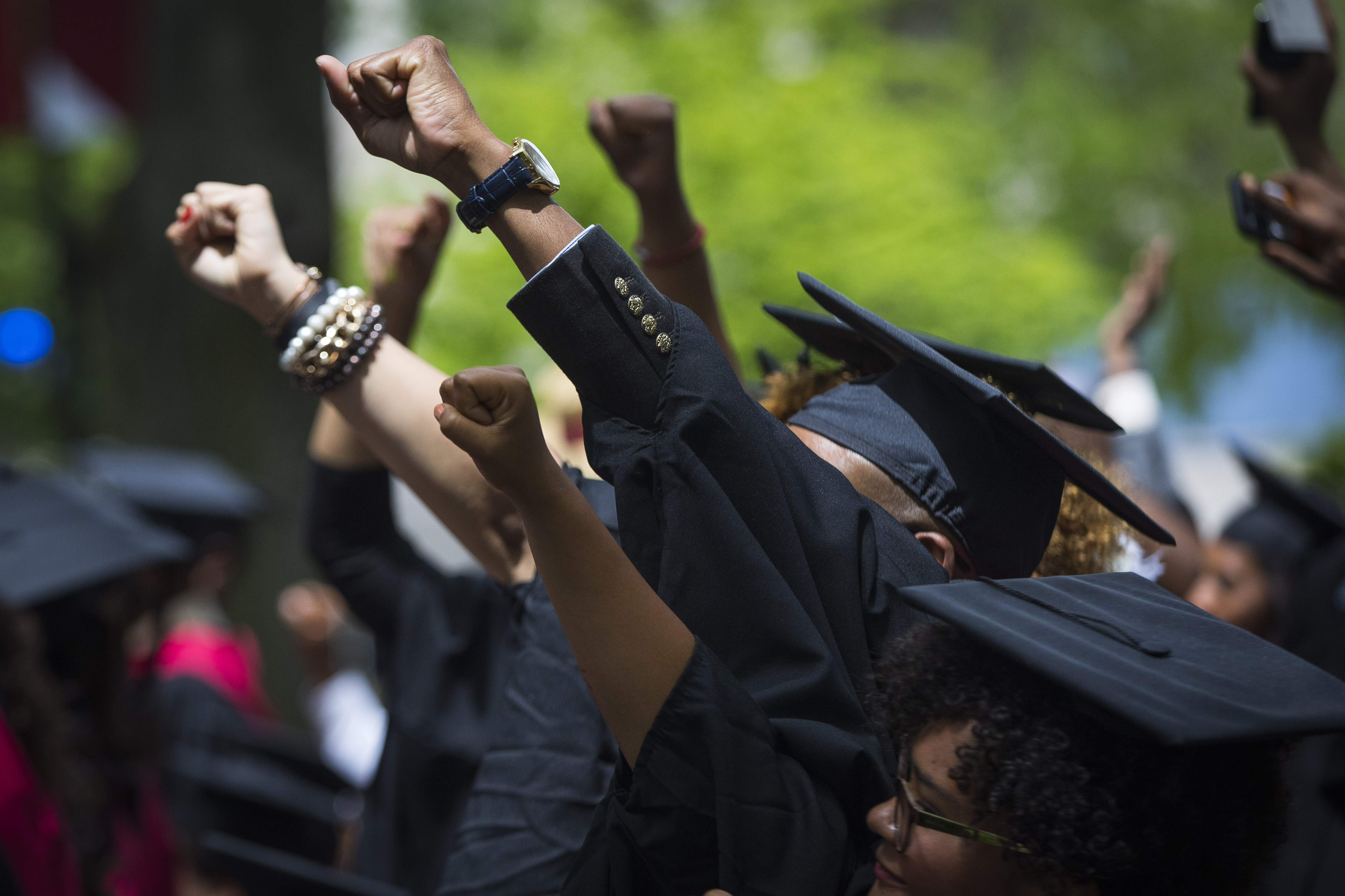 Graduates raised their fists in celebration as they took part in the Black Commencement at Harvard University.