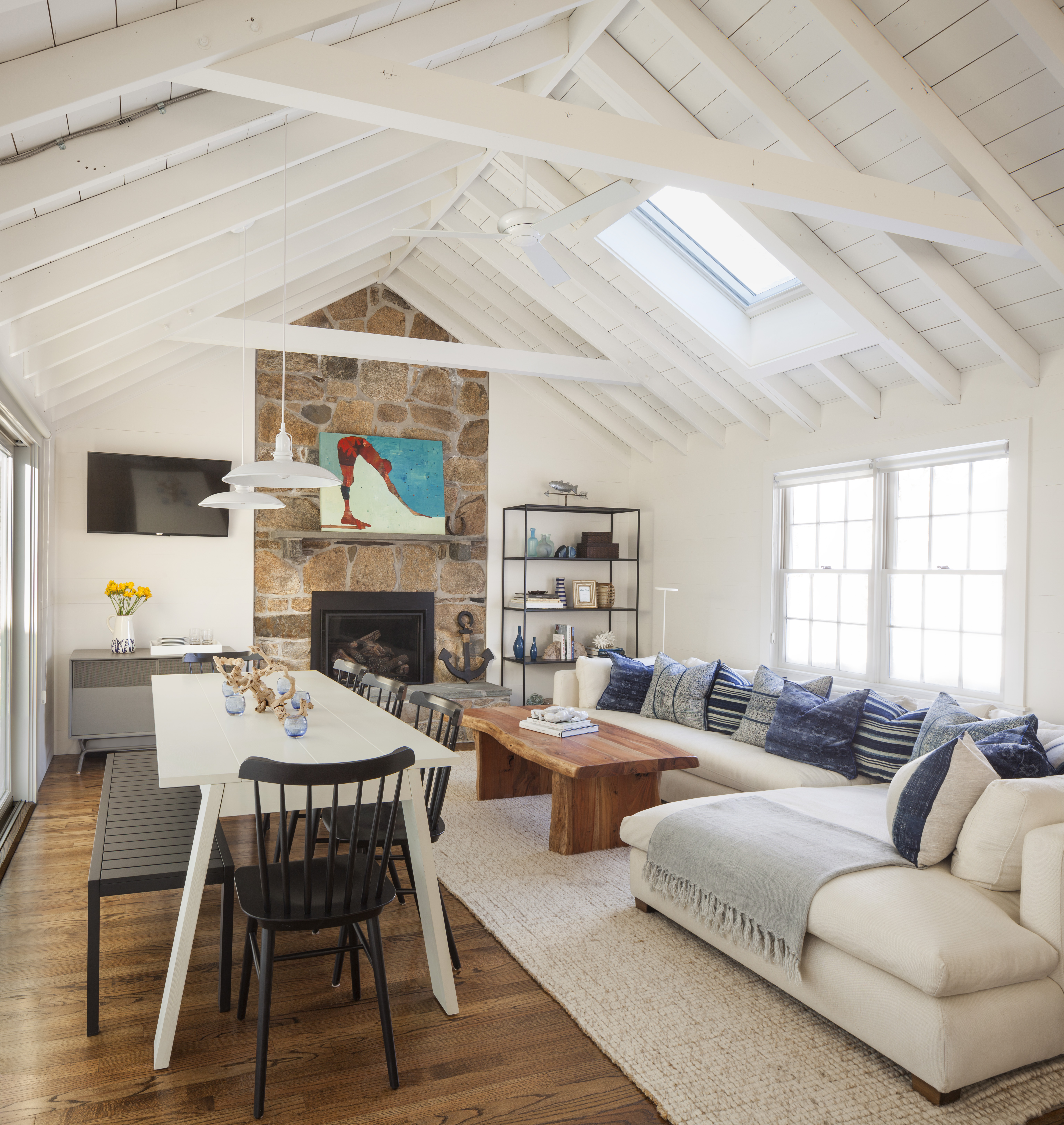 In the living/dining room, indigo blue pillows from Jayson Home and Calypso St. Barth perk up the Montauk Sofa sectional. Salt chairs from Design Within Reach have a compact footprint, and a picnic bench tucks neatly under the table when not in use. Walls and ceilings throughout are painted Benjamin Moore White Dove, a warm white that contributes to the lived-in feel.