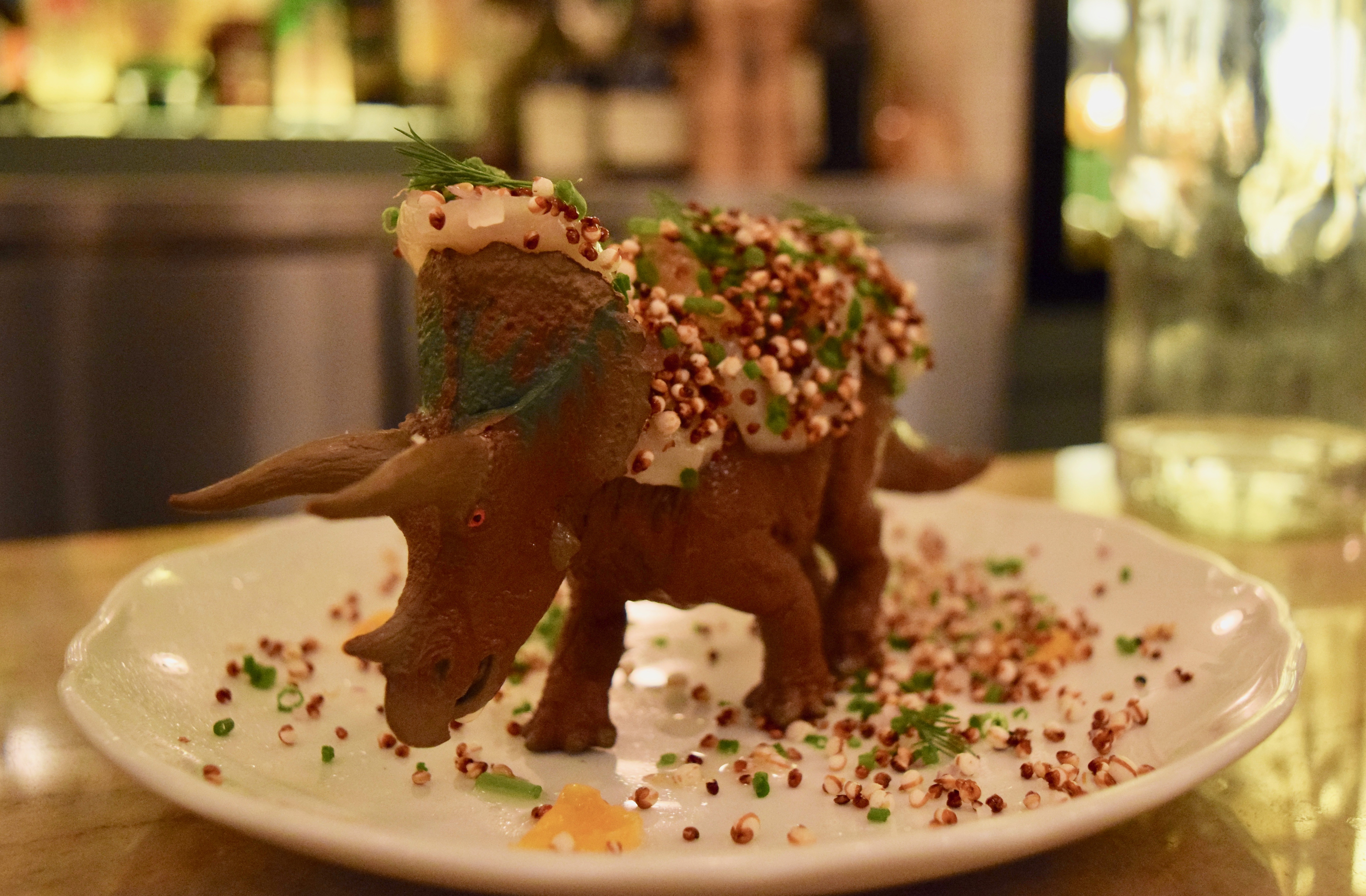 A dinosaur scallop featuring fried quinoa, clementine, and nasturtium leaf at the Montreal Plaza.