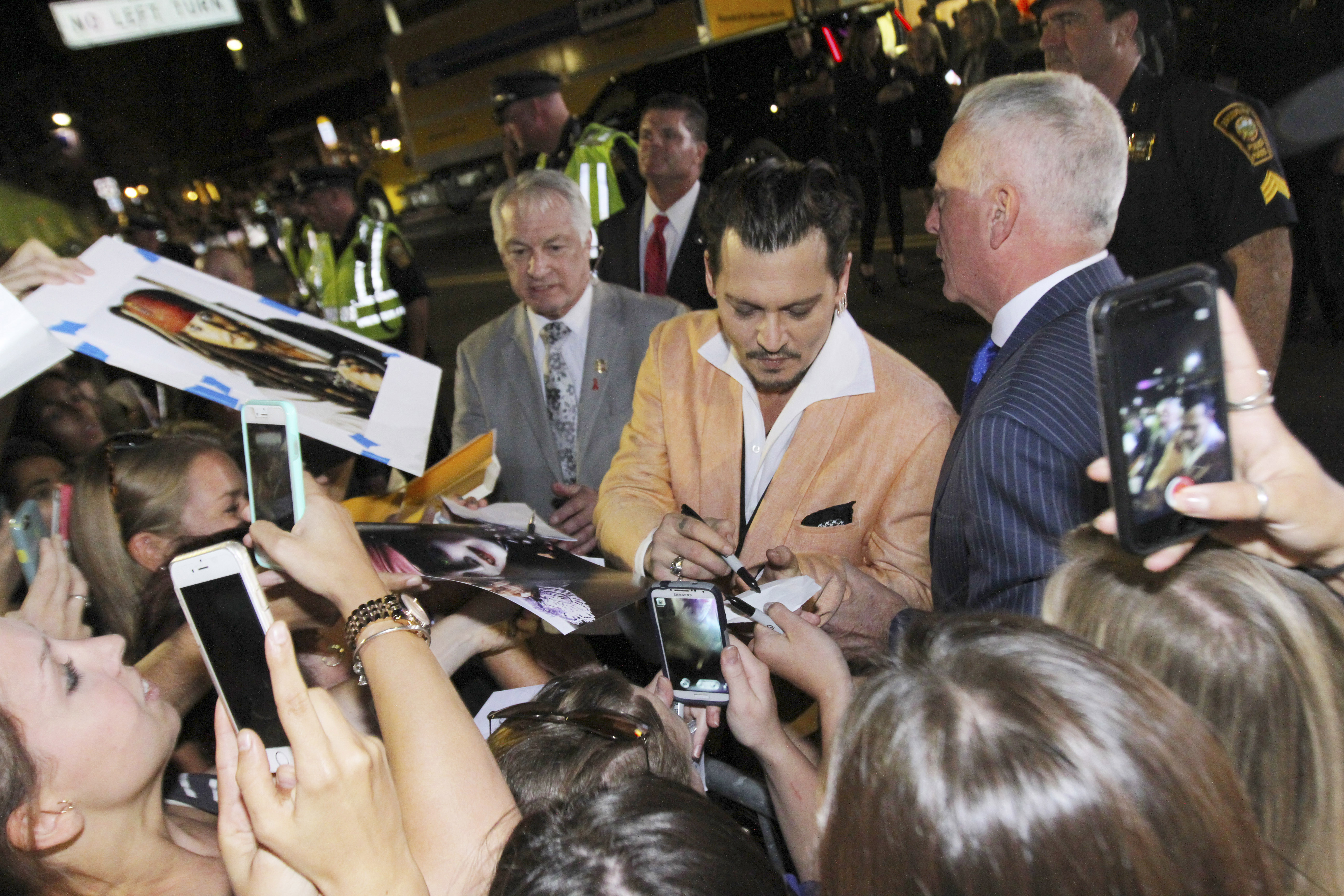 Depp signed autographs for fans upon leaving the theater.