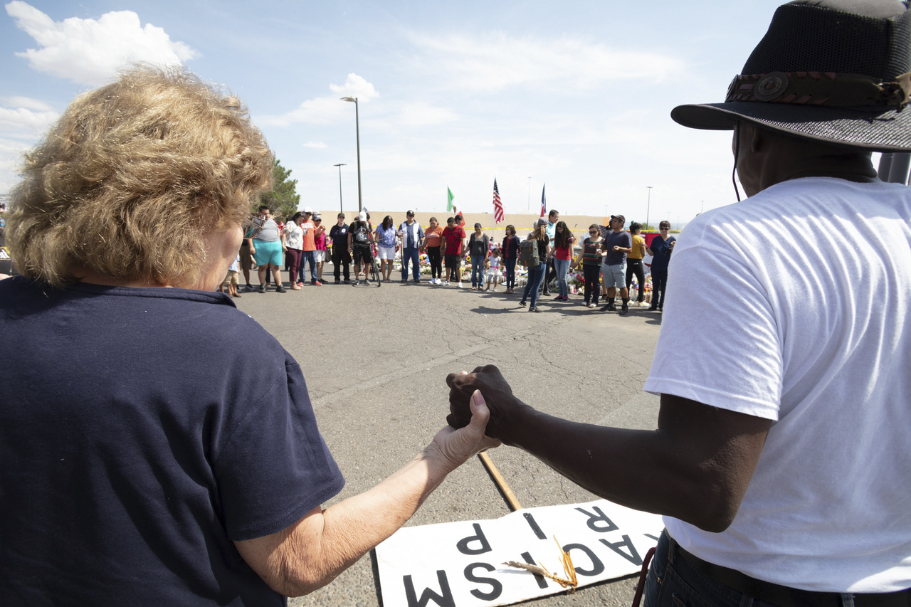 A group prayed at the memorial outside the Walmart. The site has become a gathering place to collectively share grief.