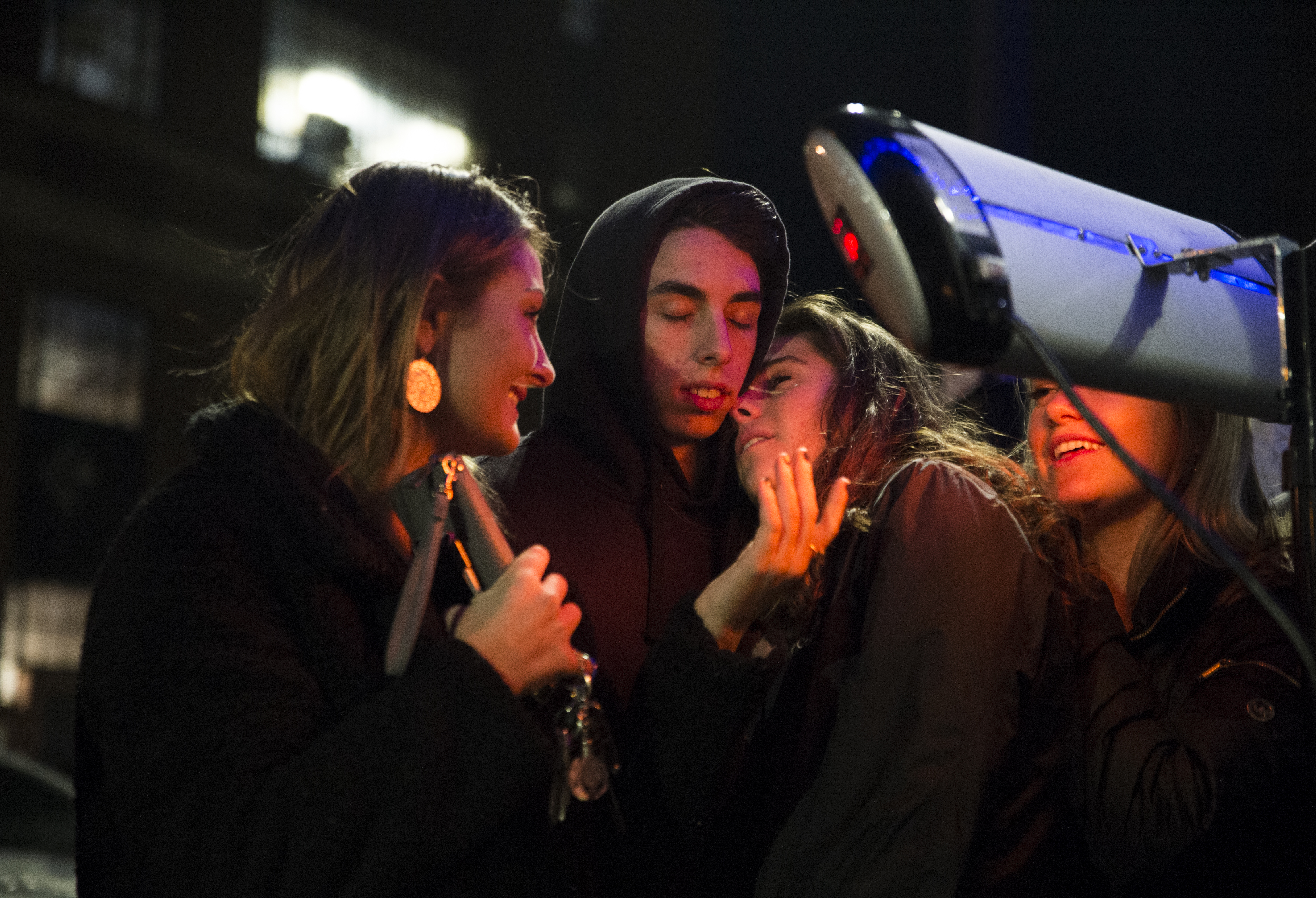 A group of people warmed up in front of a heat lamp outside the South Street Diner.