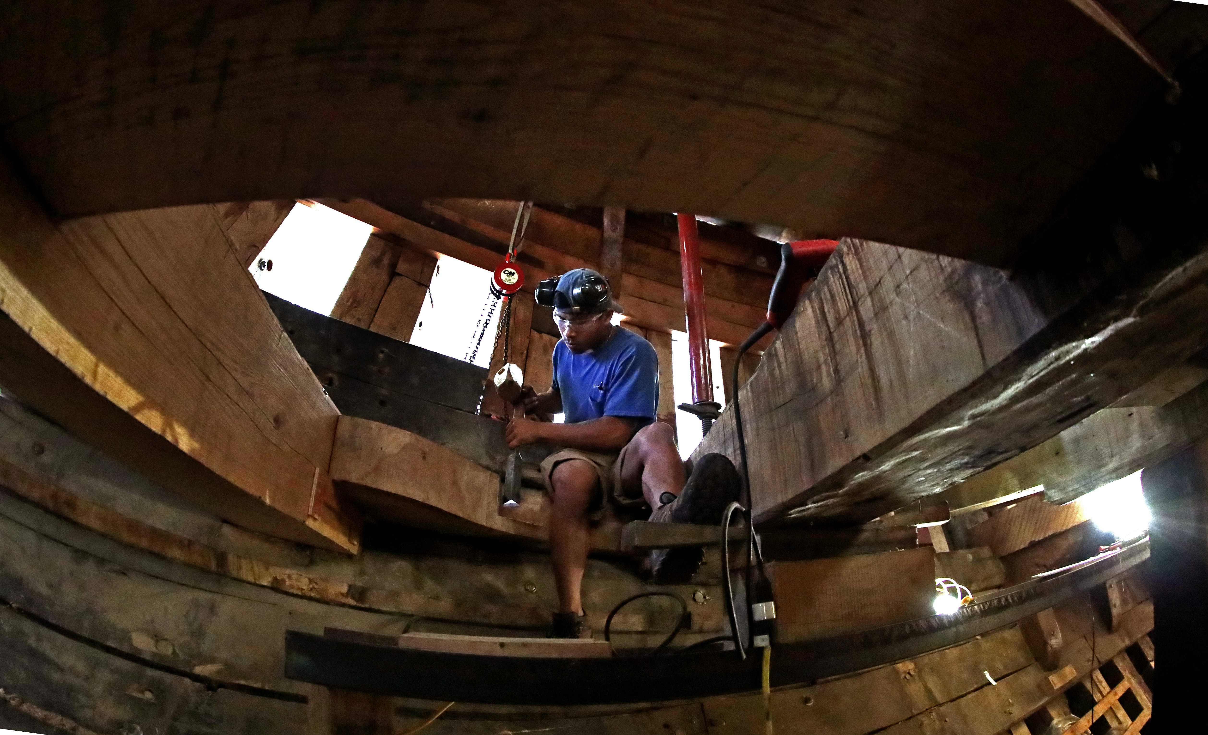 Shipwright Louie Marandola worked with a wood chisel and mallet under deck.