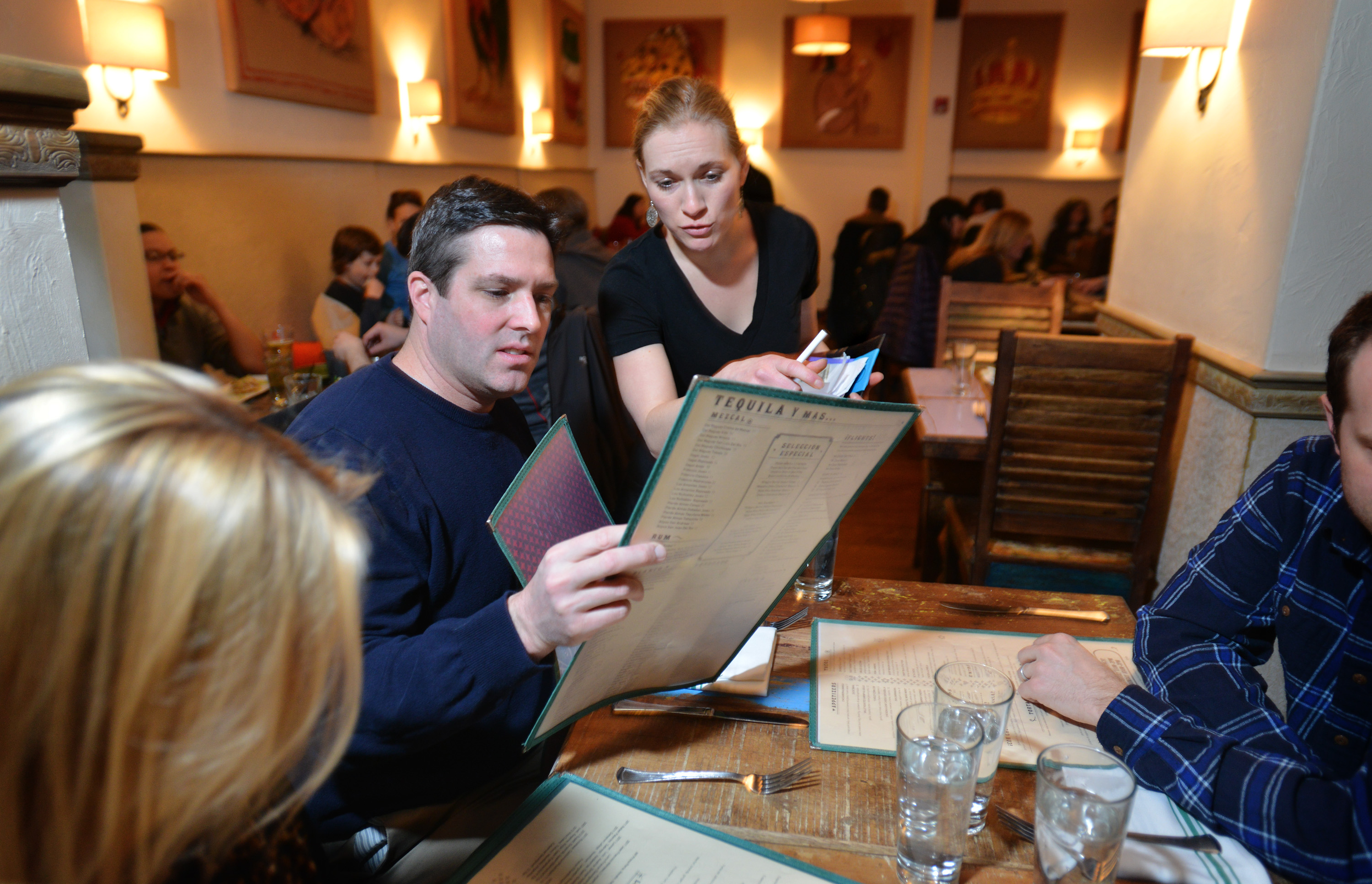 Server Meghan Drury leans in to hear as, Kevin Grant of Lynnfield places his order at The Painted Burro in Somerville. The restaurant, opened in 2012, has installed soundboards and painted with Mexican themes to look like decor in an effort to reduce the noise level in the popular Davis Square restaurant. Josh Reynolds for The Boston Globe (Lifestyle, hernandezp)