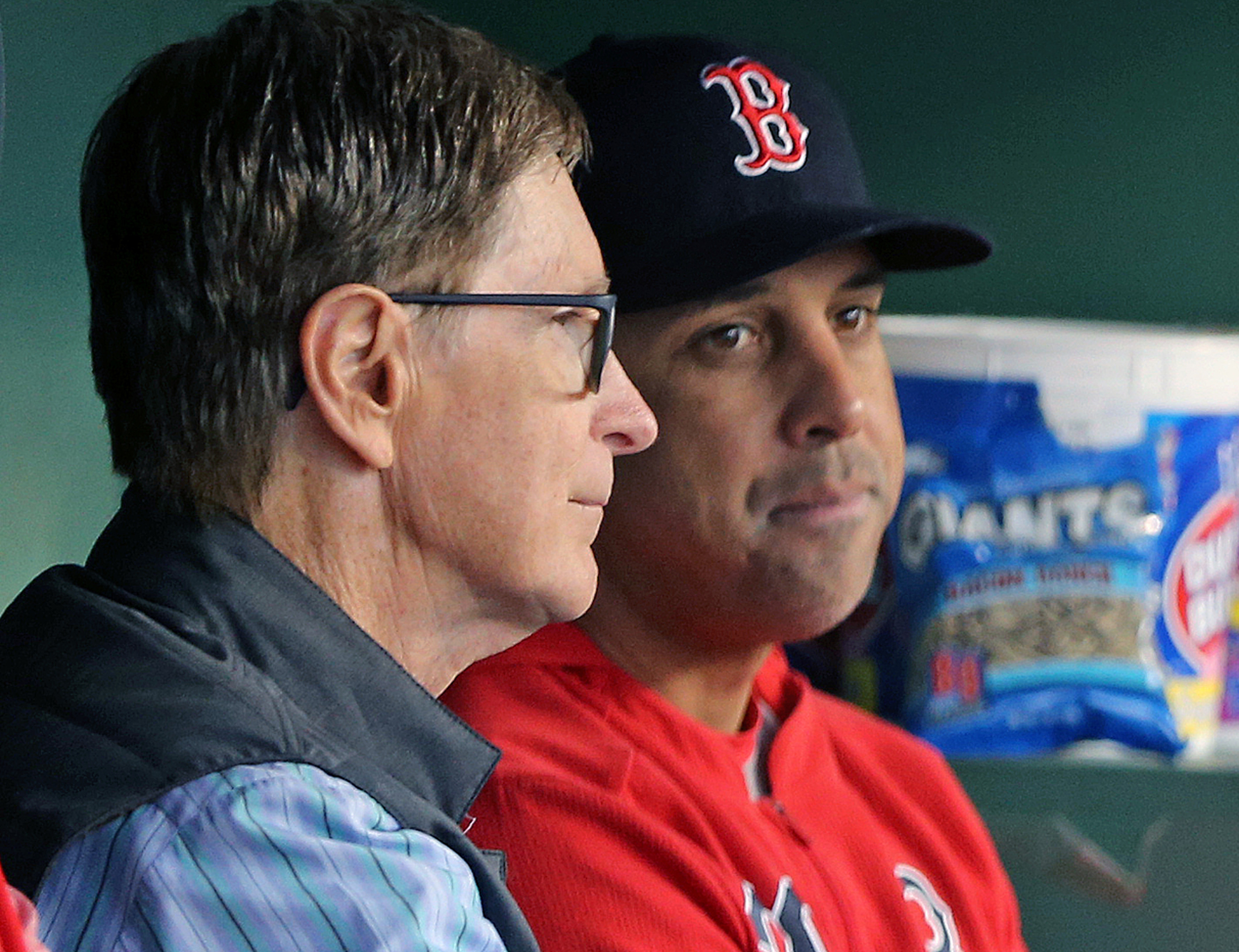John Henry and Alex Cora sit together in the Red Sox dugout before a 2019 game.