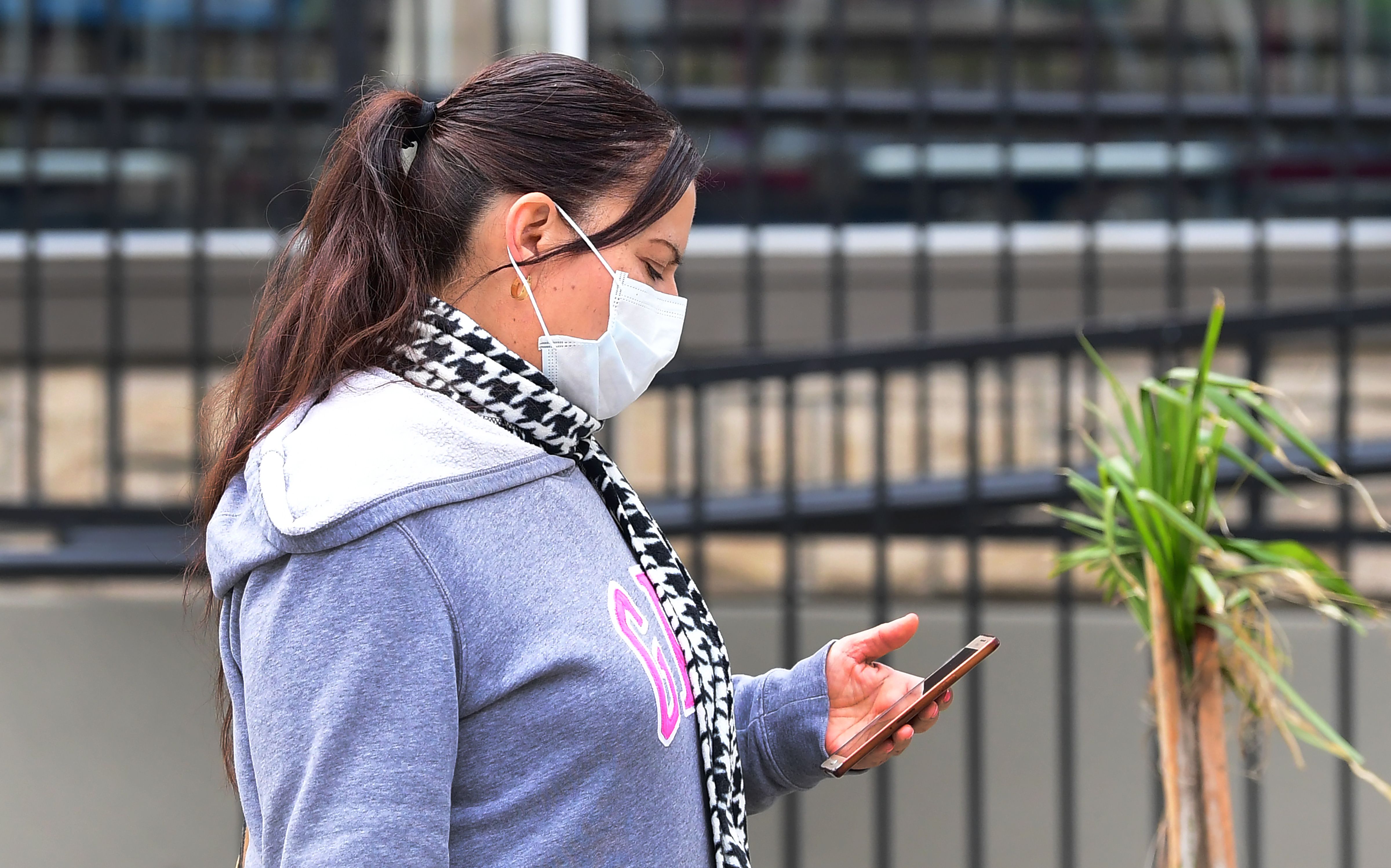 A woman checked her cellphone while wearing a facemask in Los Angeles recently.