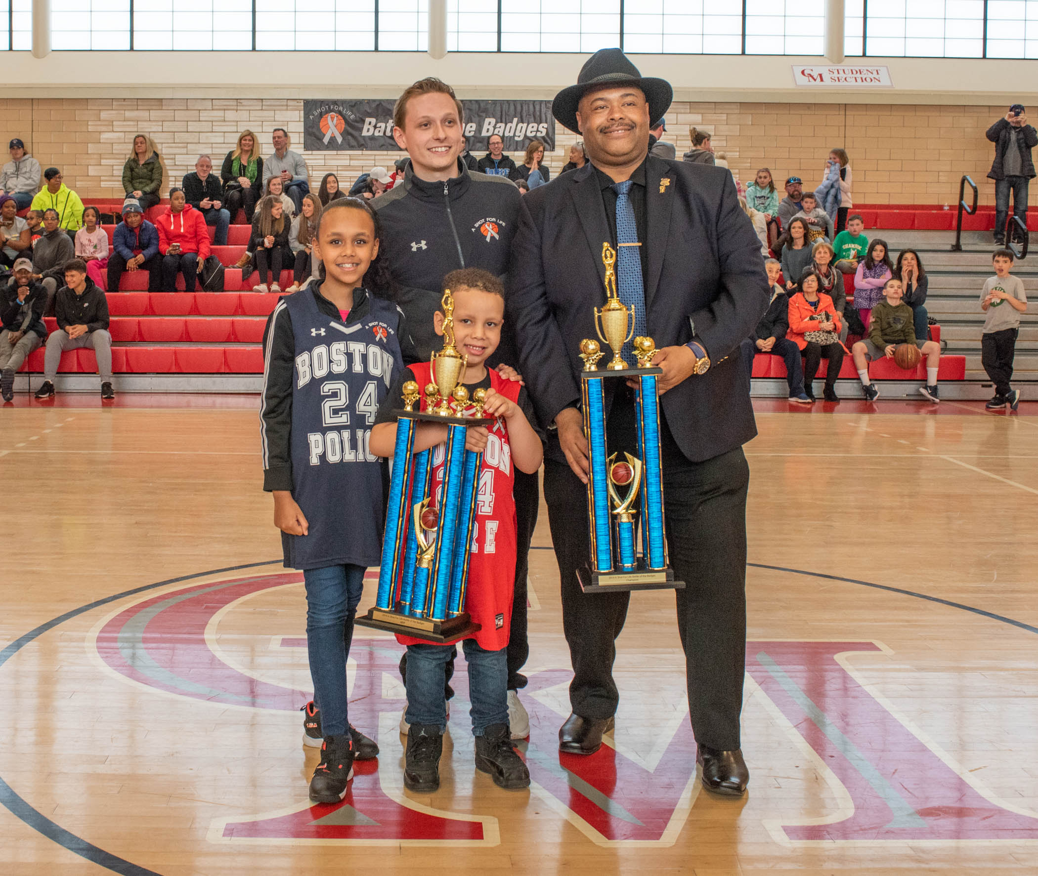 Saul Polanco served as the honorary captain at A Shot for Life’s fourth annual Battle of the Badges basketball game. With him were Mike Slonina, Boston police Commissioner William Gross, and Ashley Polanco.
