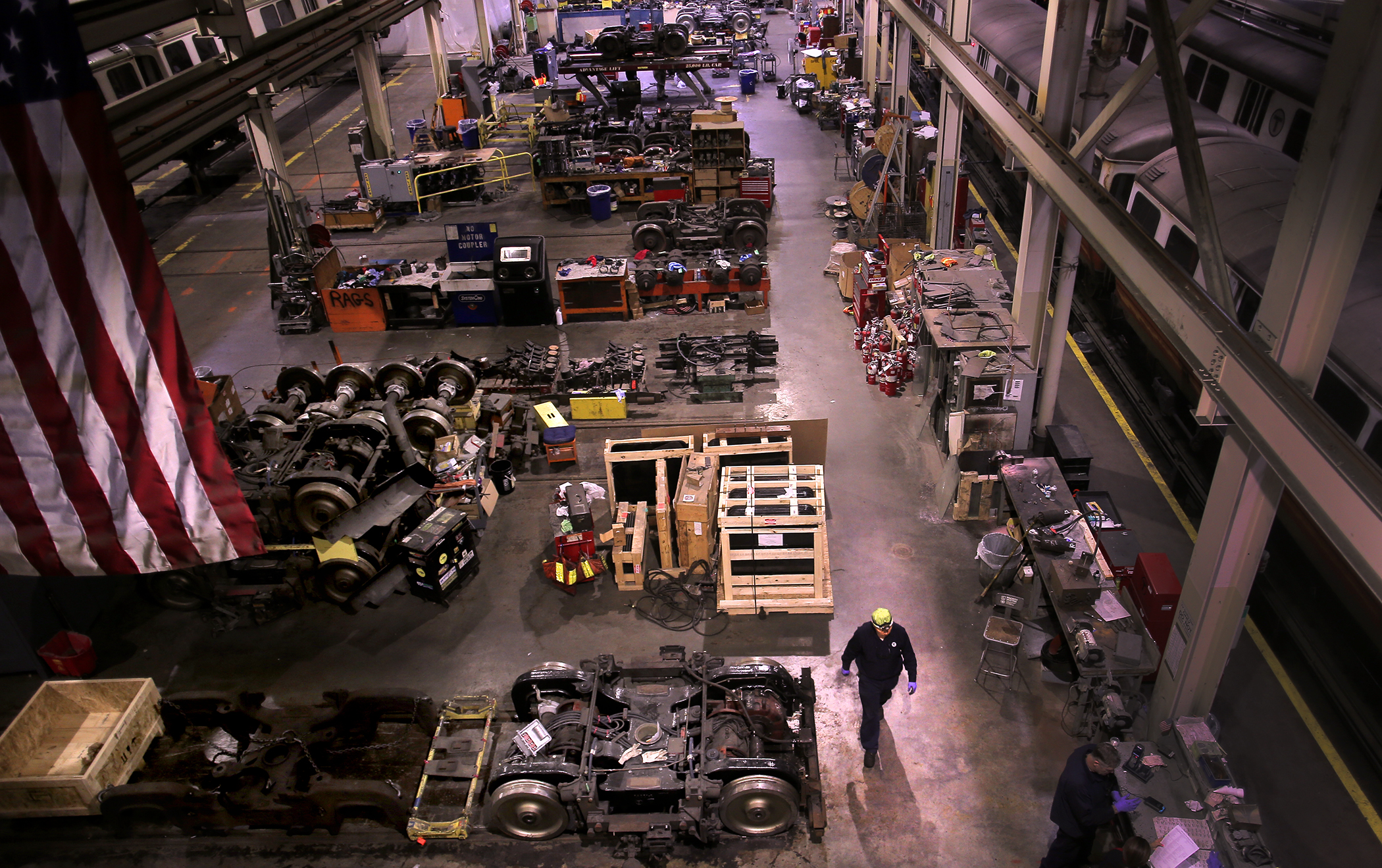 A worker walked among rail trucks and spare parts in the cavernous facility at Wellington Station.