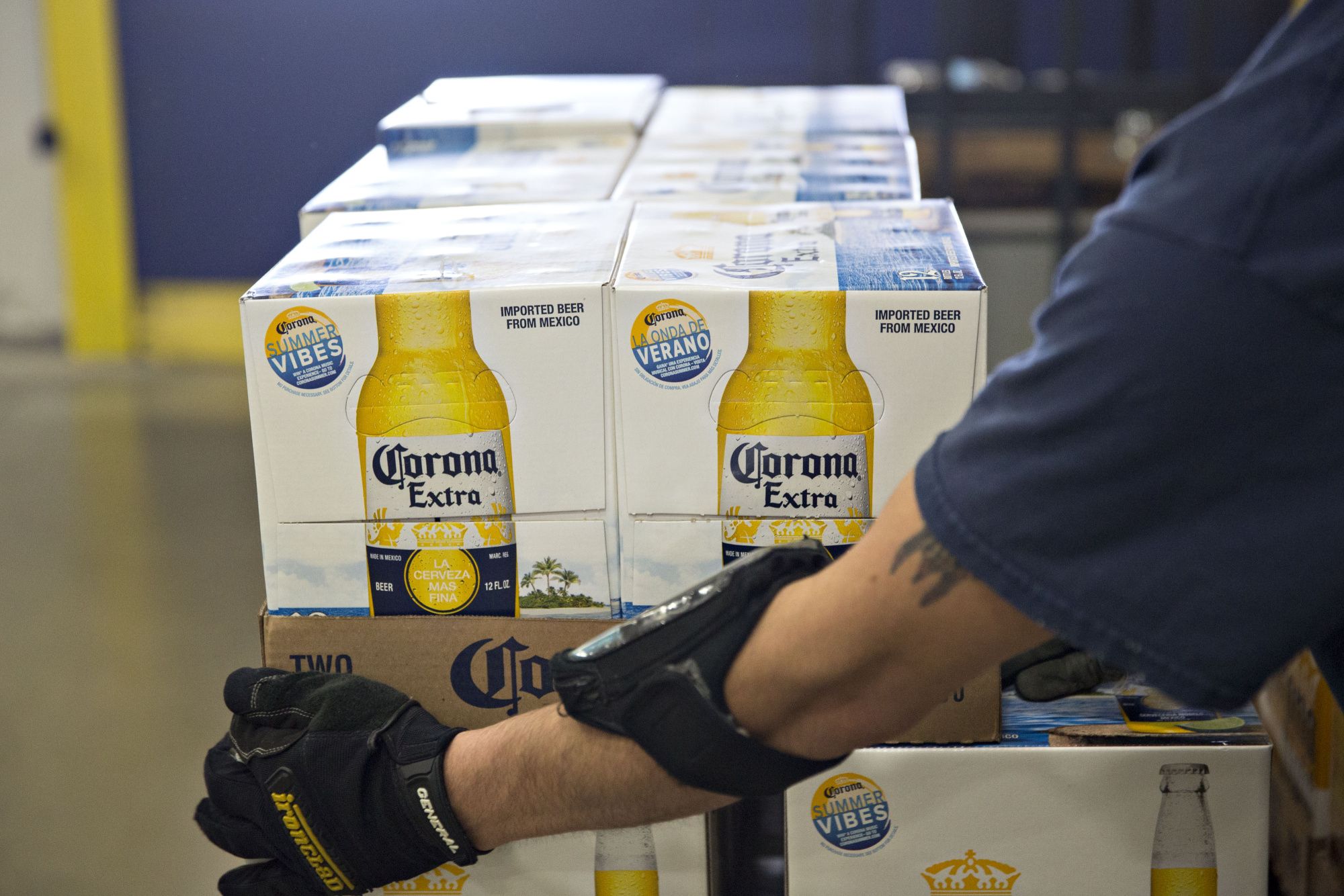 A worker carries packages of Corona beer, a brand owned by Constellation Brands, as orders are prepared for delivery in the Euclid Beverage warehouse in Peru, Illinois, U.S., on Tuesday, June 27, 2017. Constellation Brands, Inc., is expected to release quarterly earnings on June 29, 2017.