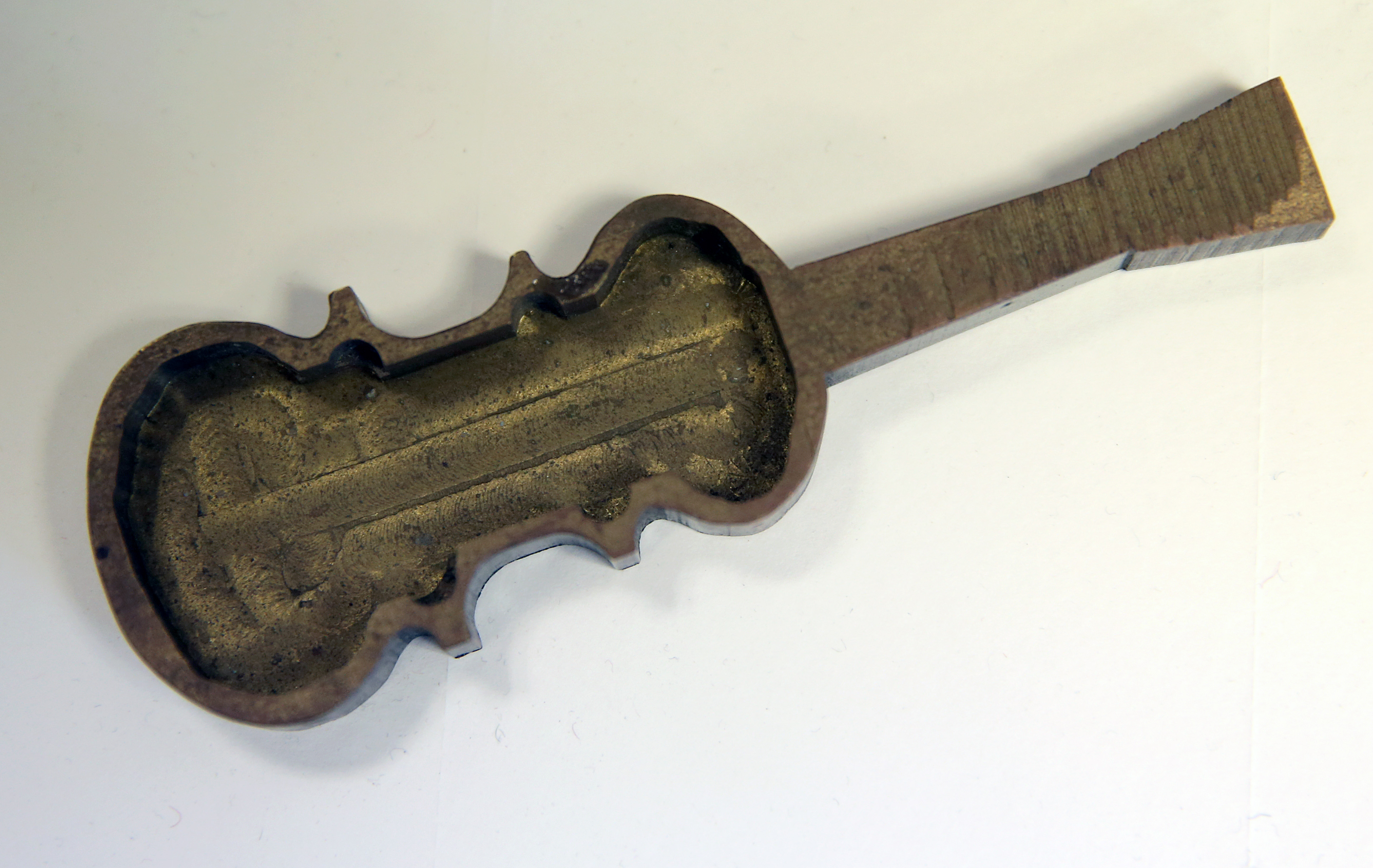 An unfinished brass violin by Abraham Megerdichian.