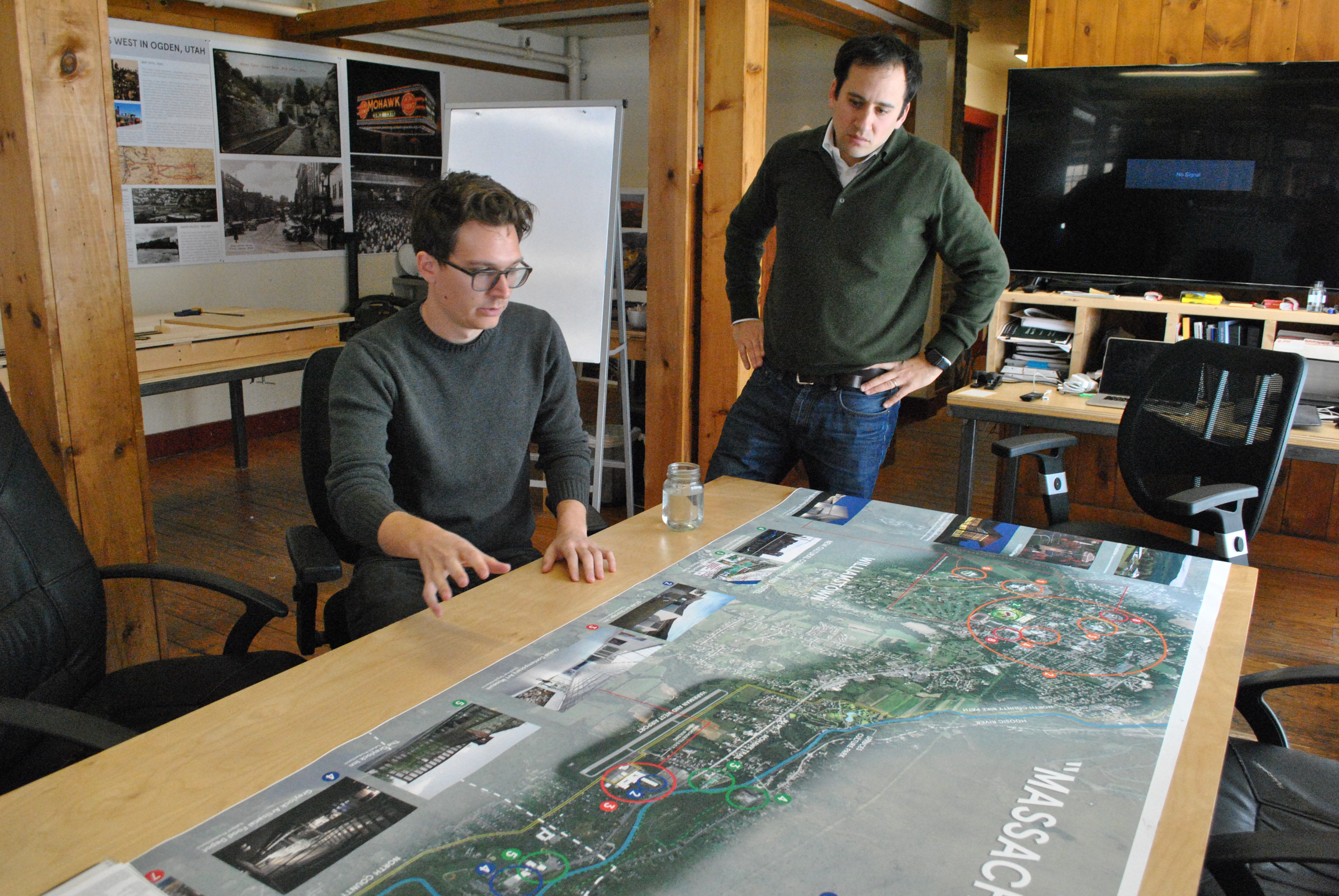 James Jarzyniecki (left) and Ben Sosne look at a map of cultural attractions in North Adams and Williamstown that includes proposed projects, among them the Extreme Model Railroad and Contemporary Architecture Museum intended for North Adams.