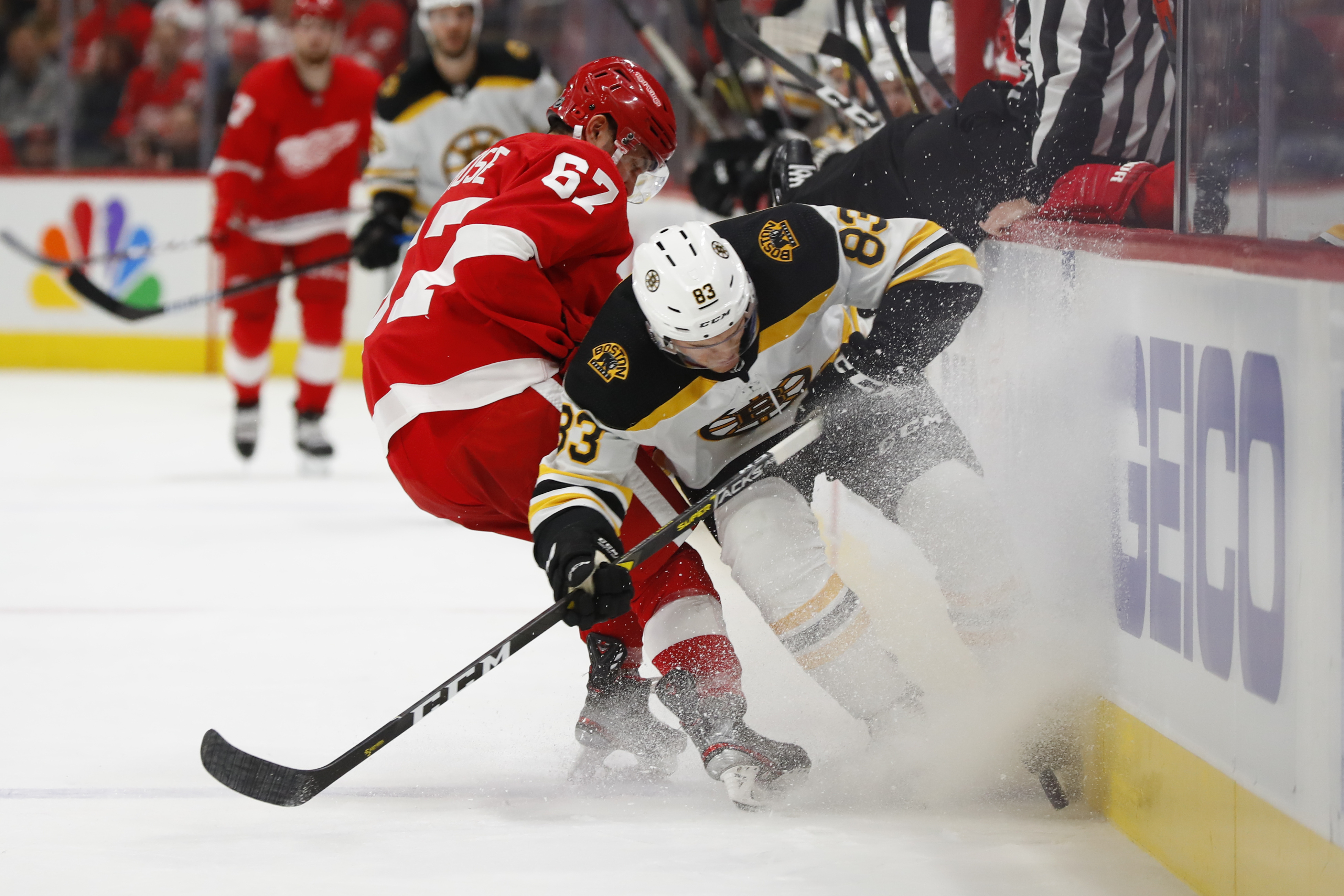The Red Wings’ Taro Hirose and Bruin Karson Kuhlman battle for the puck in the second period.