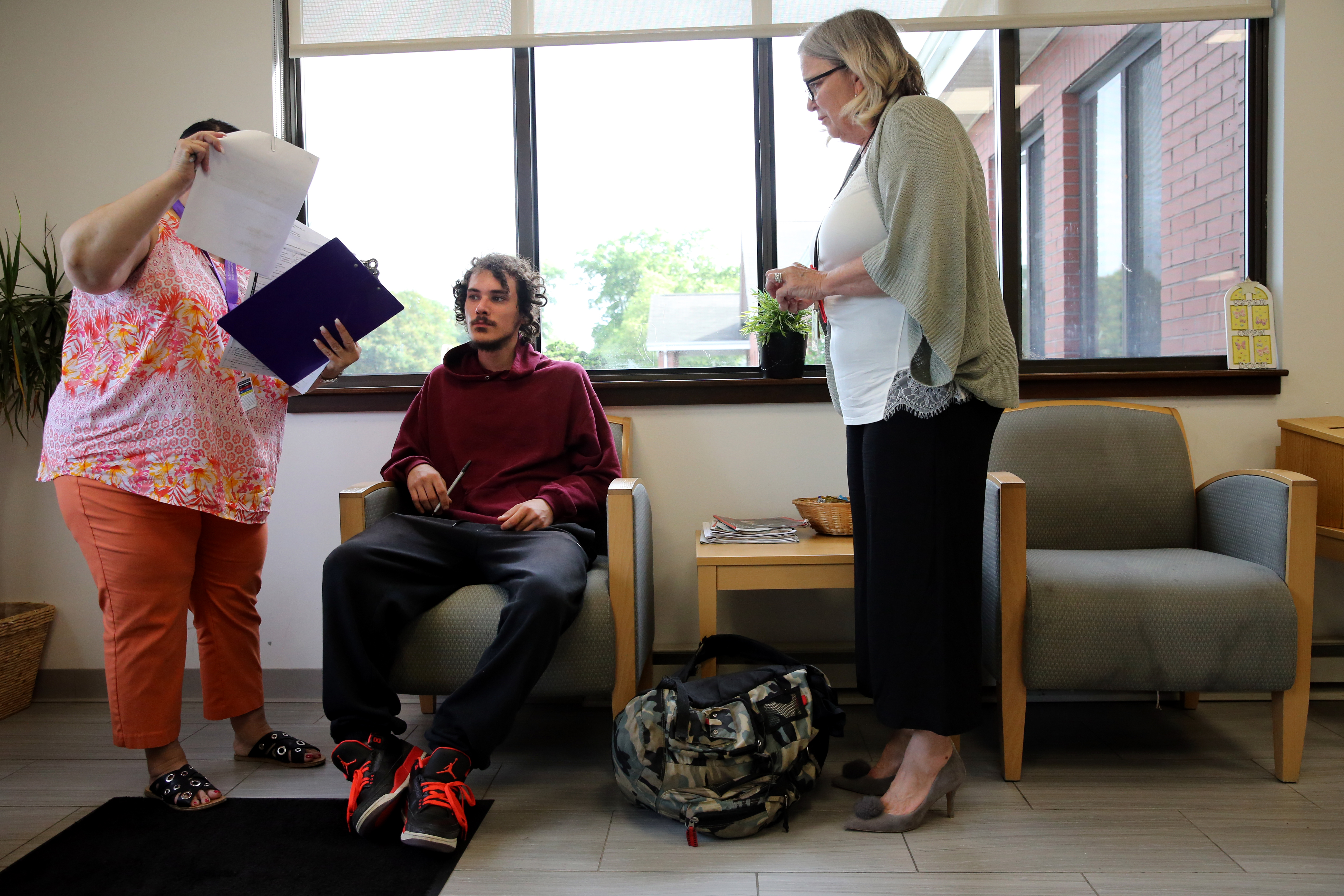 Adam Carreira, 22, of New Bedford (center) talked with intake worker Deborah Booker (left) and OTC Clinician Kathy Belanger at the Open Access Clinic at SSTAR, a treatment facility in Fall River.