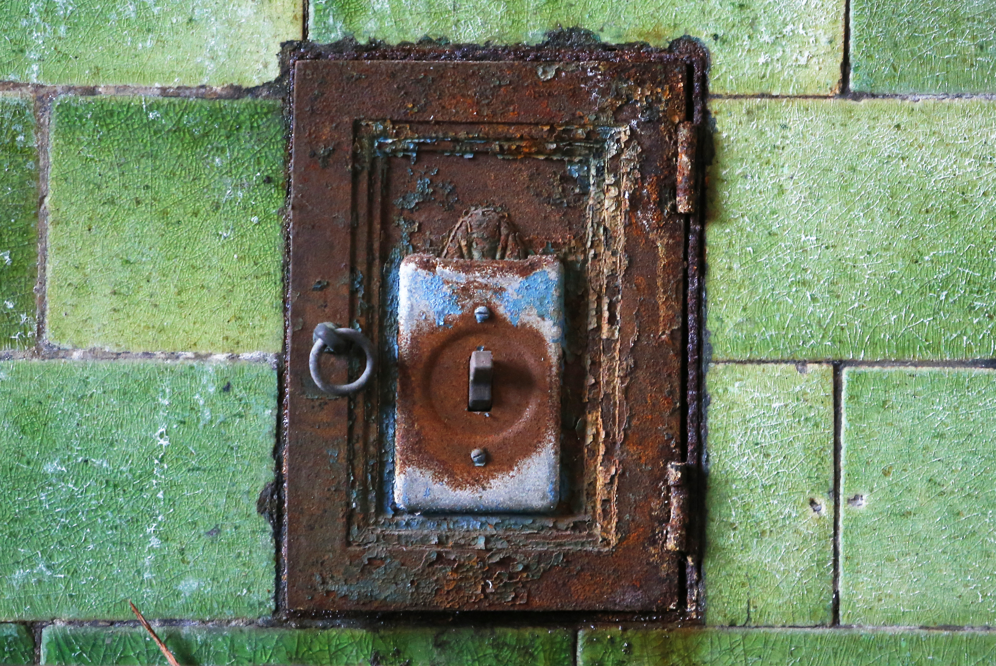 A light switch with a patina of fading paint is set against a rusting door inside the L Street Power Station.